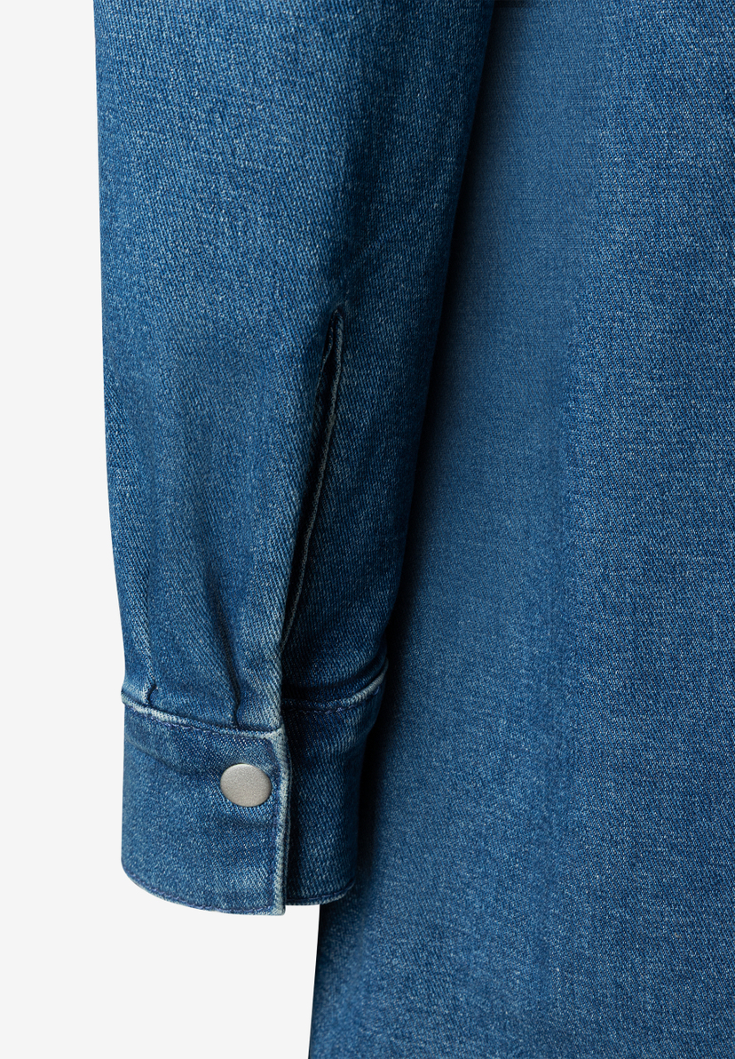 Detailaufnahme eines blauen Jeansstoff-Oberteils von MORE & MORE, das angenehm und elastisch ist. Detailaufnahme eines blauen Jeansstoff-Oberteils von MORE & MORE, das angenehm und elastisch ist.