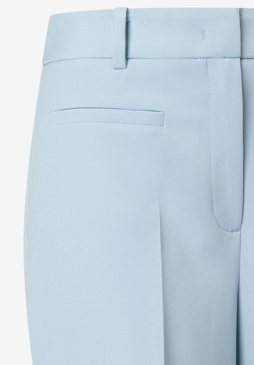 Detailansicht einer hellblauen Hose von MORE & MORE, die eine Tasche und Gürtelschlaufen zeigt. Detailansicht einer hellblauen Hose von MORE & MORE, die eine Tasche und Gürtelschlaufen zeigt.