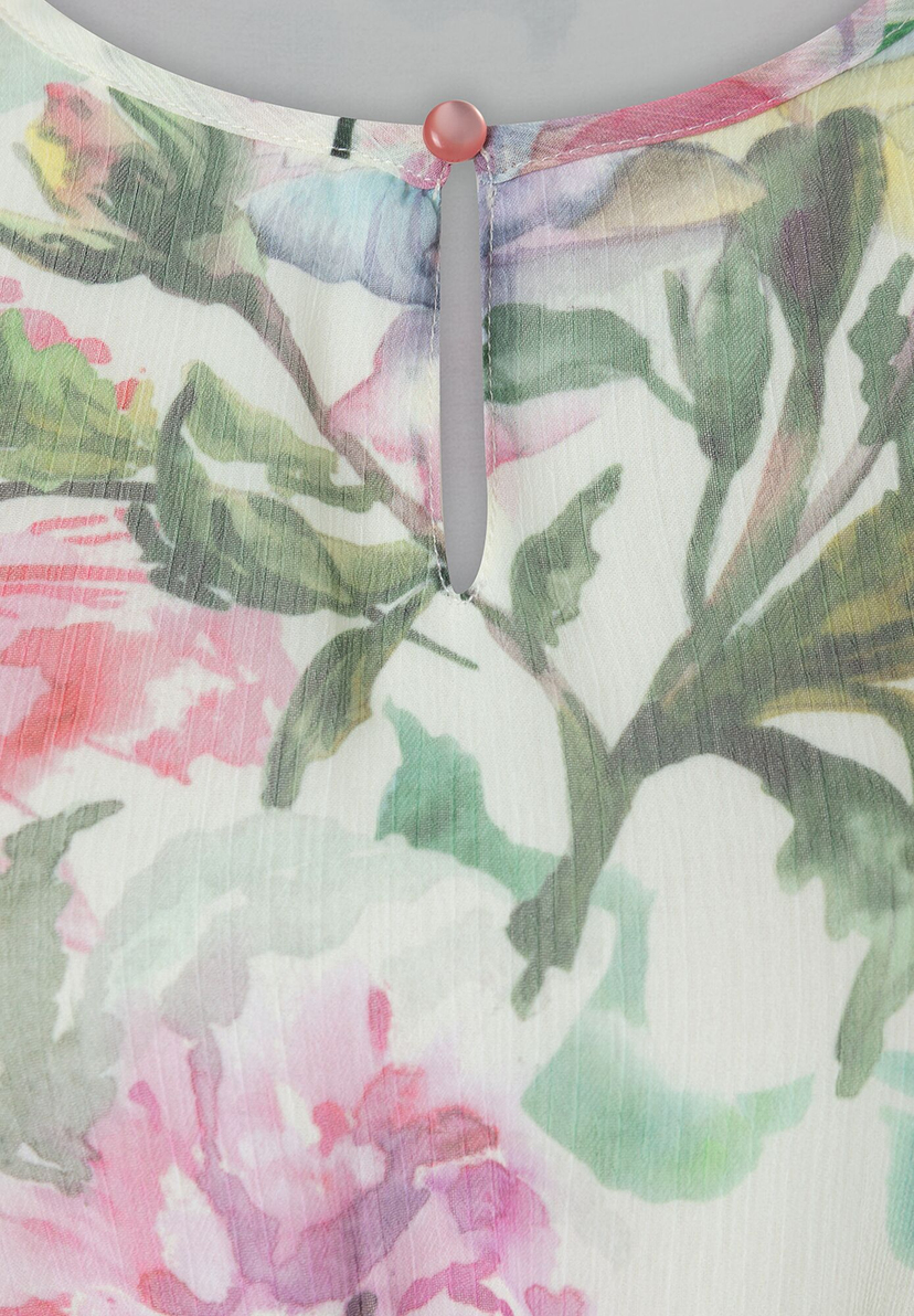 Nahaufnahme von MORE & MORE Oberteil mit Blumenmuster und Knopfdetail. Nahaufnahme von MORE & MORE Oberteil mit Blumenmuster und Knopfdetail.