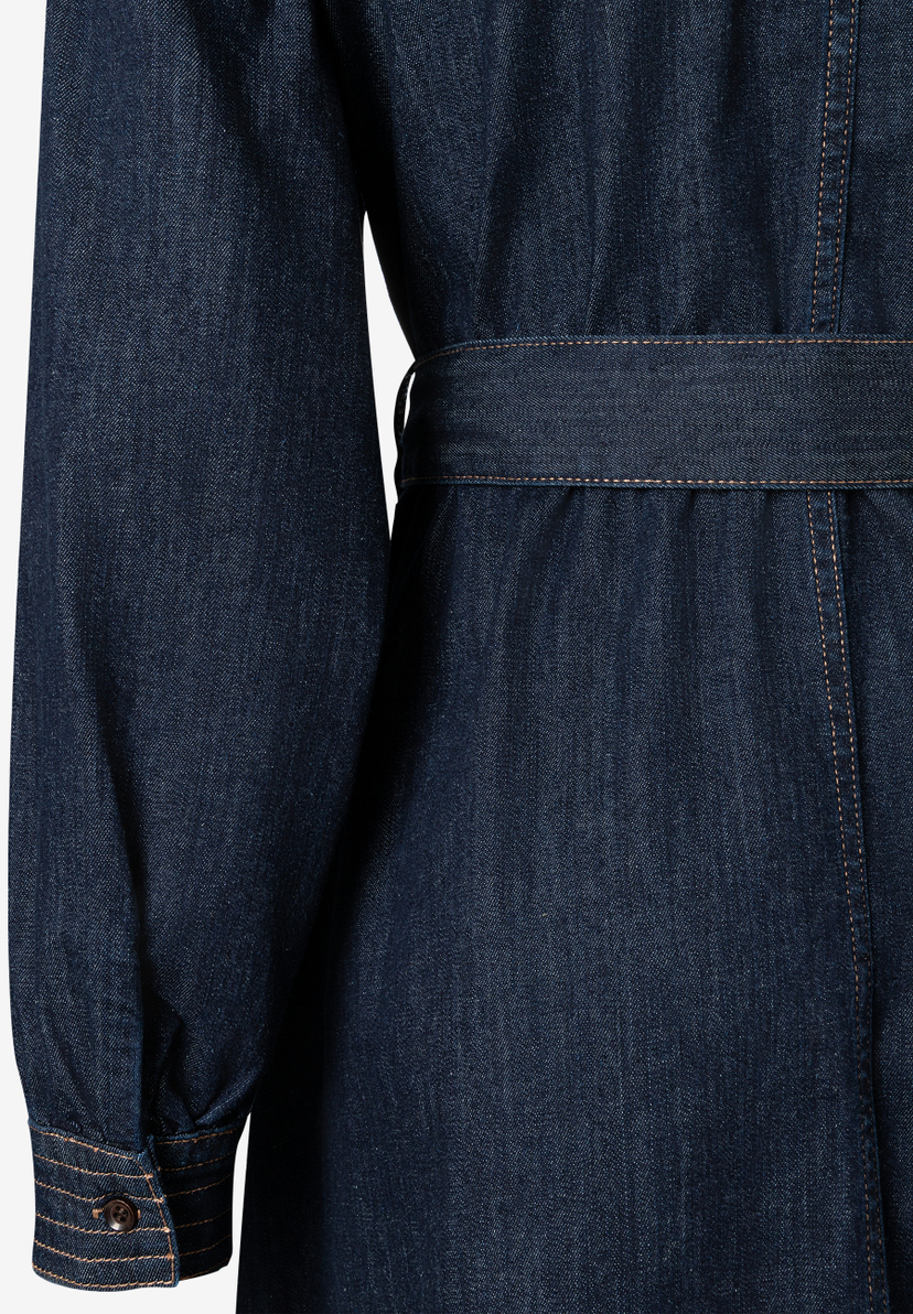 Detailaufnahme eines MORE & MORE Oberteils aus Jeansstoff mit Ärmel und Gürtel. Detailaufnahme eines MORE & MORE Oberteils aus Jeansstoff mit Ärmel und Gürtel.