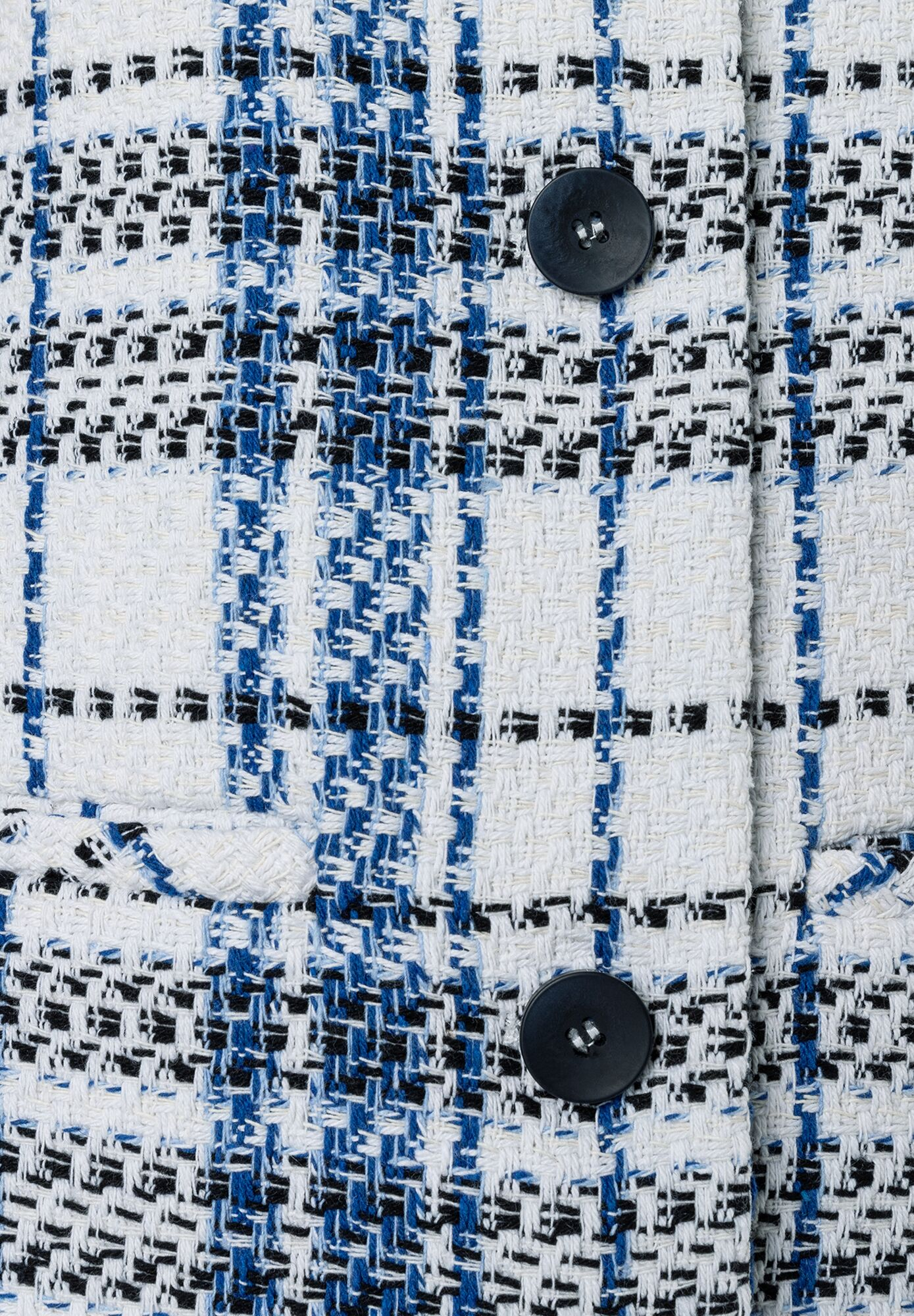 Detailaufnahme eines MORE & MORE Blazers mit Bouclé-Muster in Weiß, Blau und Schwarz, geschlossen mit zwei Knöpfen. Detailaufnahme eines MORE & MORE Blazers mit Bouclé-Muster in Weiß, Blau und Schwarz, geschlossen mit zwei Knöpfen.