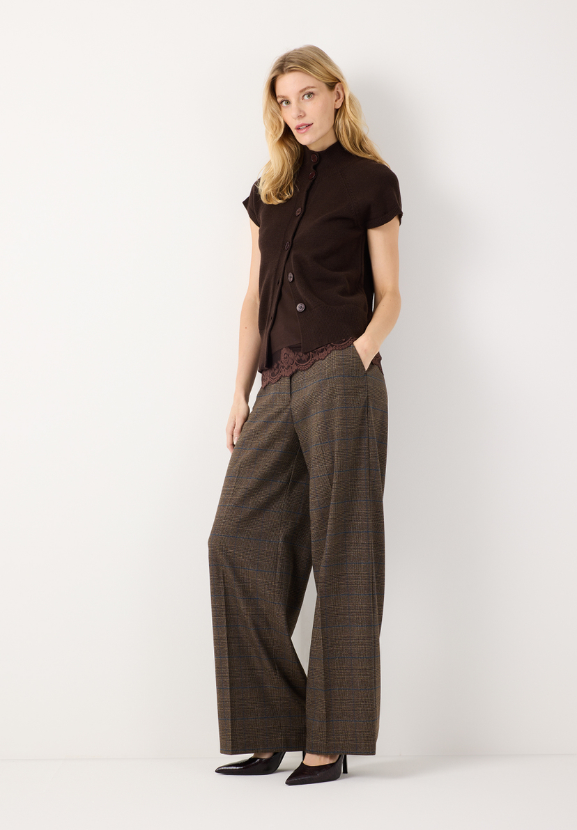 MORE & MORE Pullover: Eine Frau in einem braunen Feinstrickpullover mit Knopfleiste & einer gemusterten Hose.