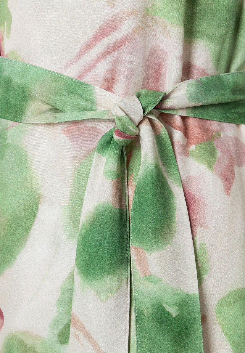 Detailaufnahme eines MORE & MORE Oberteils aus Satin mit Blumenmuster und gebundenem Gürtel. Detailaufnahme eines MORE & MORE Oberteils aus Satin mit Blumenmuster und gebundenem Gürtel.