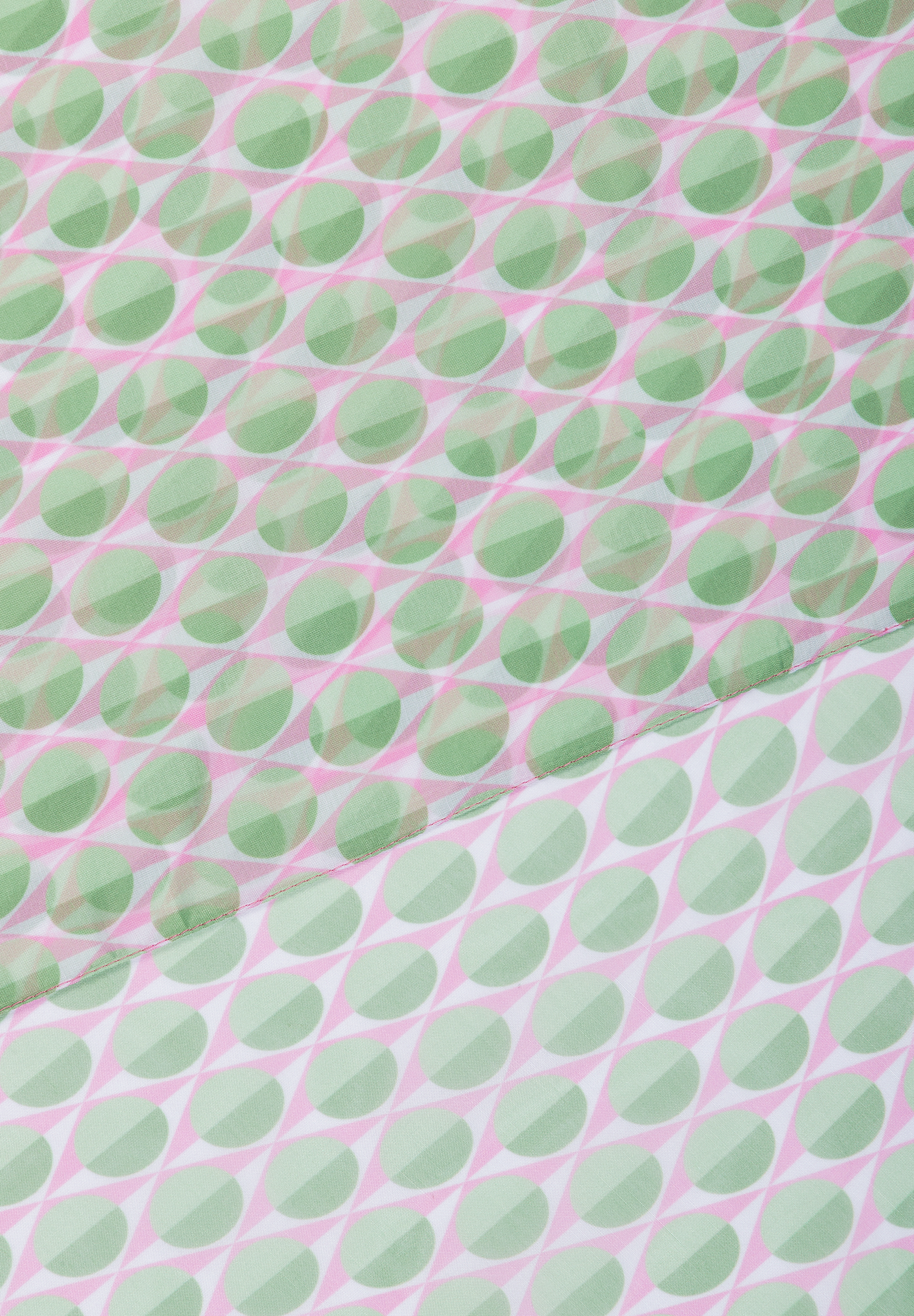 Ein Accessoire von MORE & MORE mit einem Muster aus grünen Kreisen auf rosa Rauten. Ein Accessoire von MORE & MORE mit einem Muster aus grünen Kreisen auf rosa Rauten.