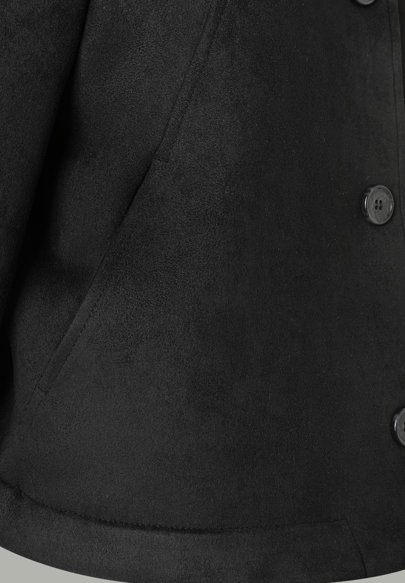 Nahaufnahme eines schwarzen MORE & MORE Blazers mit Knopfdetail und angedeuteter Tasche. Nahaufnahme eines schwarzen MORE & MORE Blazers mit Knopfdetail und angedeuteter Tasche.