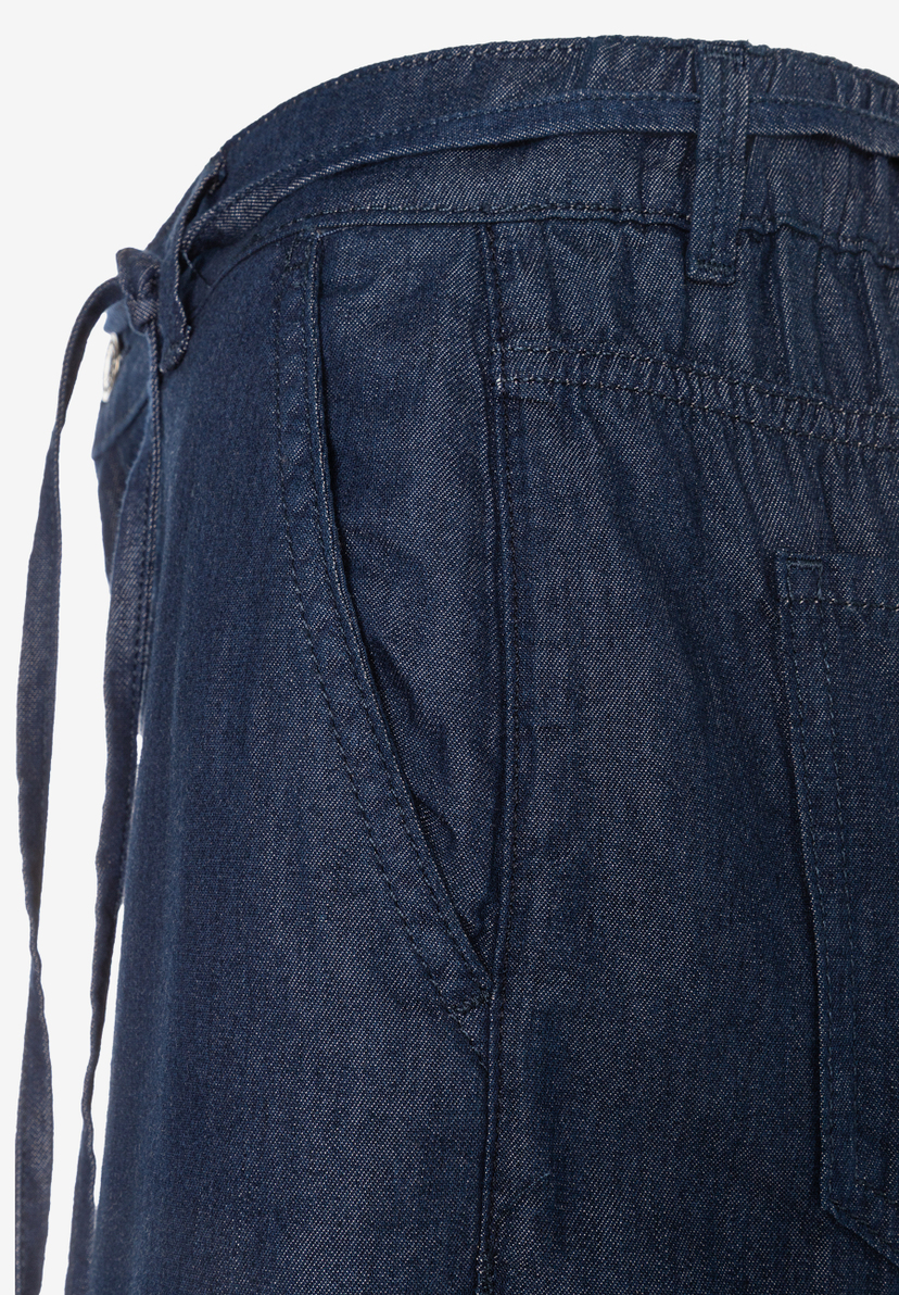 MORE & MORE Jeans: Nahaufnahme einer dunkelblauen Jeanshose mit seitlicher Tasche und Bindeband, weicher Denim MORE & MORE Jeans: Nahaufnahme einer dunkelblauen Jeanshose mit seitlicher Tasche und Bindeband, weicher Denim