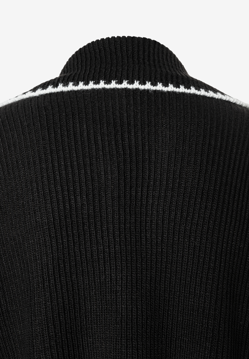 Nahaufnahme eines schwarzen MORE & MORE Strickoberteils mit weißem Akzent am Kragen. Nahaufnahme eines schwarzen MORE & MORE Strickoberteils mit weißem Akzent am Kragen.