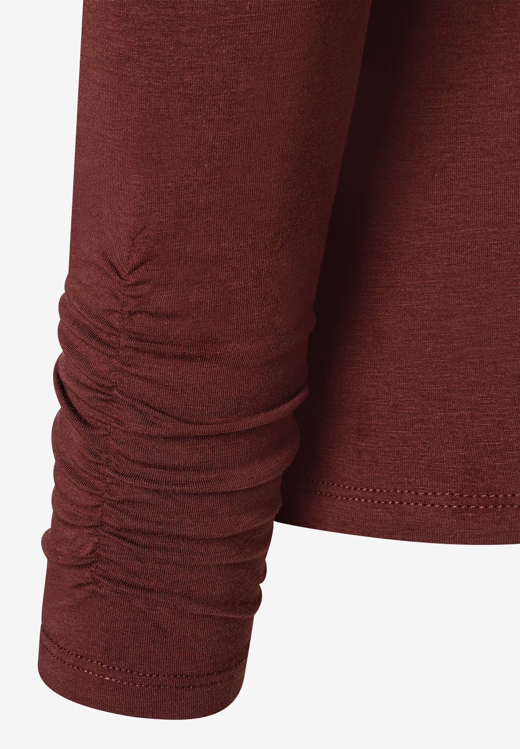 Nahaufnahme eines bordeauxroten MORE & MORE Oberteils mit gerafften Ärmeln. Nahaufnahme eines bordeauxroten MORE & MORE Oberteils mit gerafften Ärmeln.