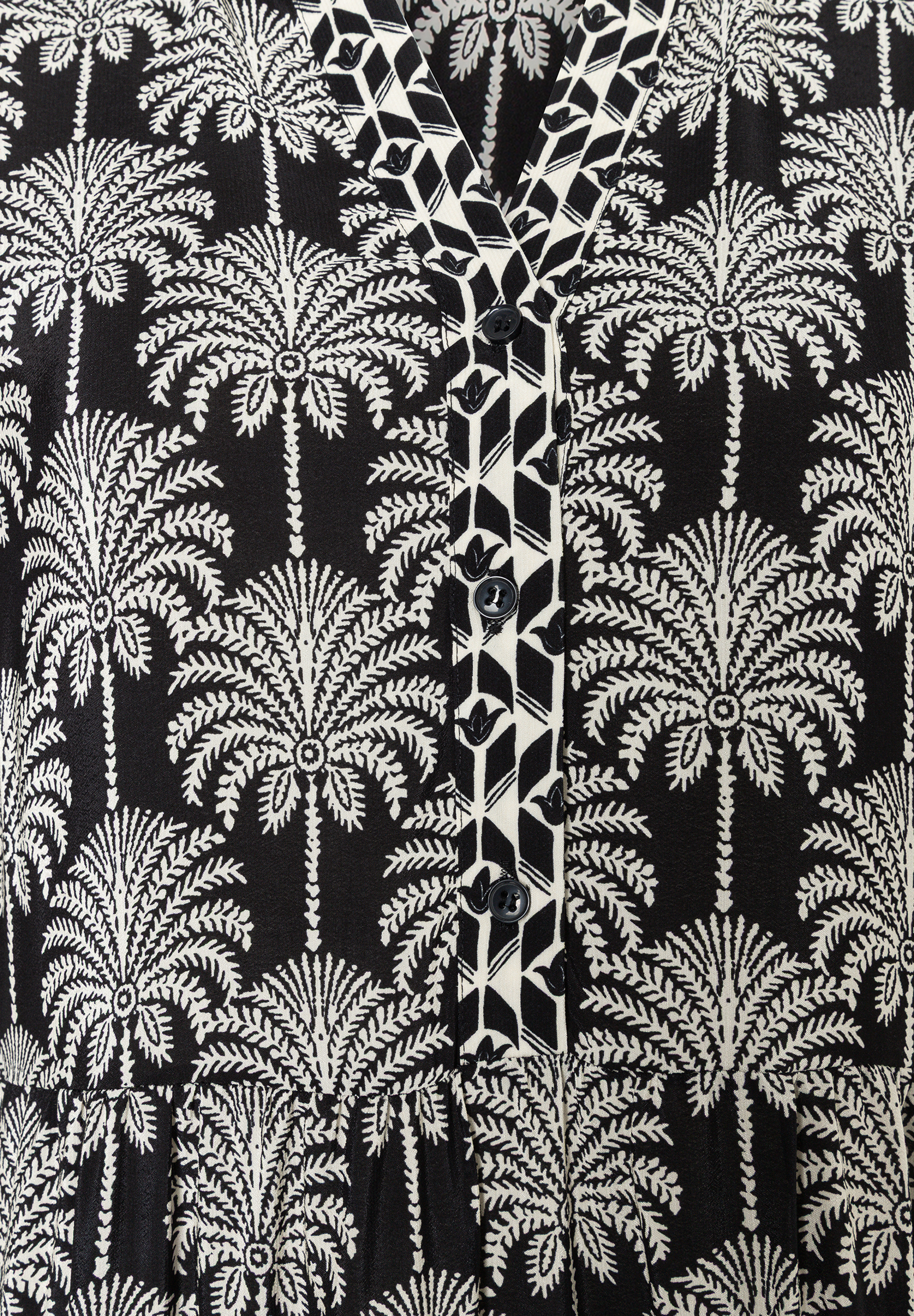 MORE & MORE Oberteil: Schwarzes Kleid mit weißem Palmenmuster und V-Ausschnitt mit Knopfleiste und geometrischem Muster. MORE & MORE Oberteil: Schwarzes Kleid mit weißem Palmenmuster und V-Ausschnitt mit Knopfleiste und geometrischem Muster.