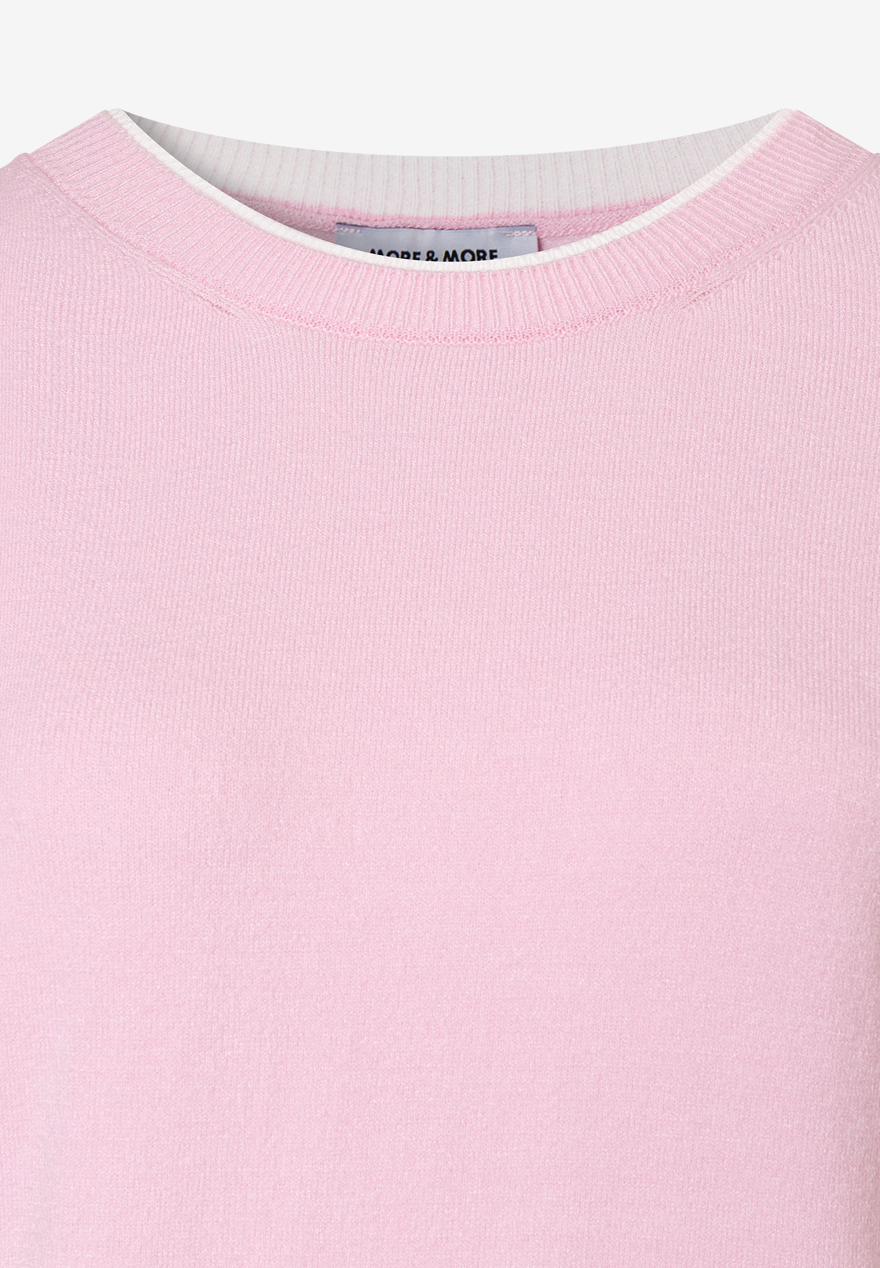 Ein Detailansicht eines rosa MORE & MORE Feinstrick-Pullovers mit weißem Kragen. Ein Detailansicht eines rosa MORE & MORE Feinstrick-Pullovers mit weißem Kragen.