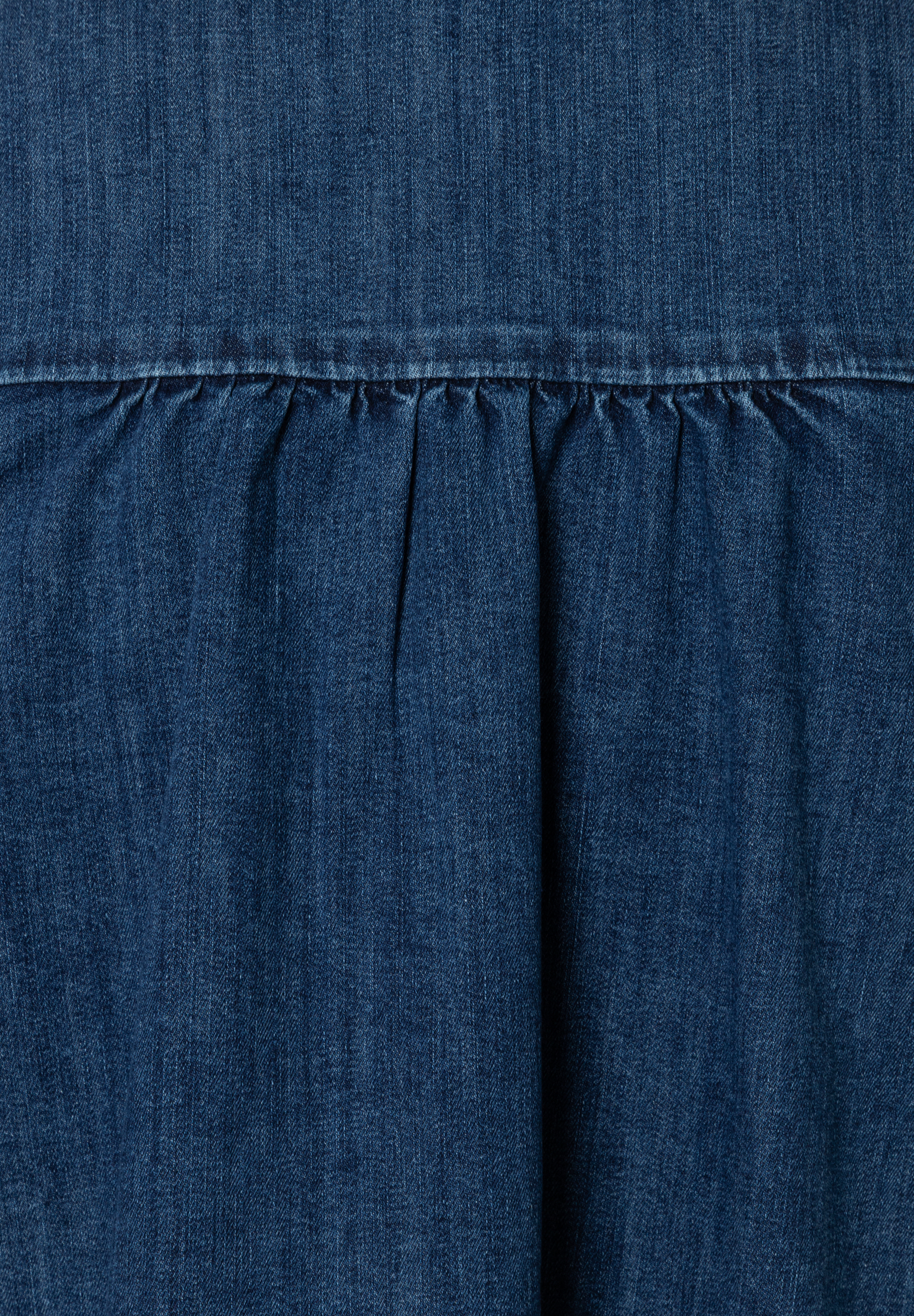 Nahaufnahme eines MORE & MORE Oberteils aus Denim, das elastisch ist und angenehm zu tragen ist. Nahaufnahme eines MORE & MORE Oberteils aus Denim, das elastisch ist und angenehm zu tragen ist.