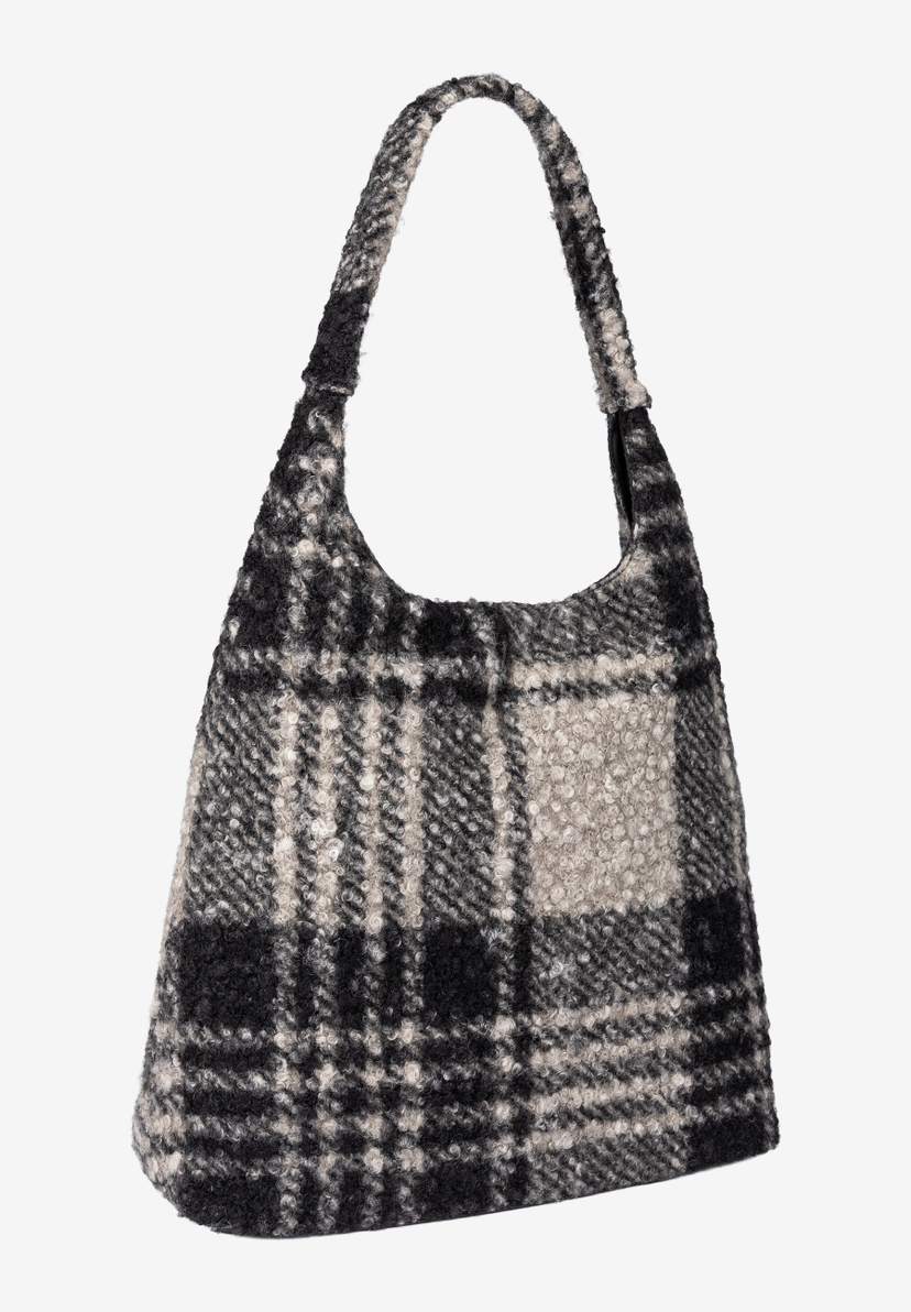 MORE & MORE Accessoire: Eine schwarze und cremefarbene karierte Handtasche mit Plüscheffekt, die Textur und Muster vereint.