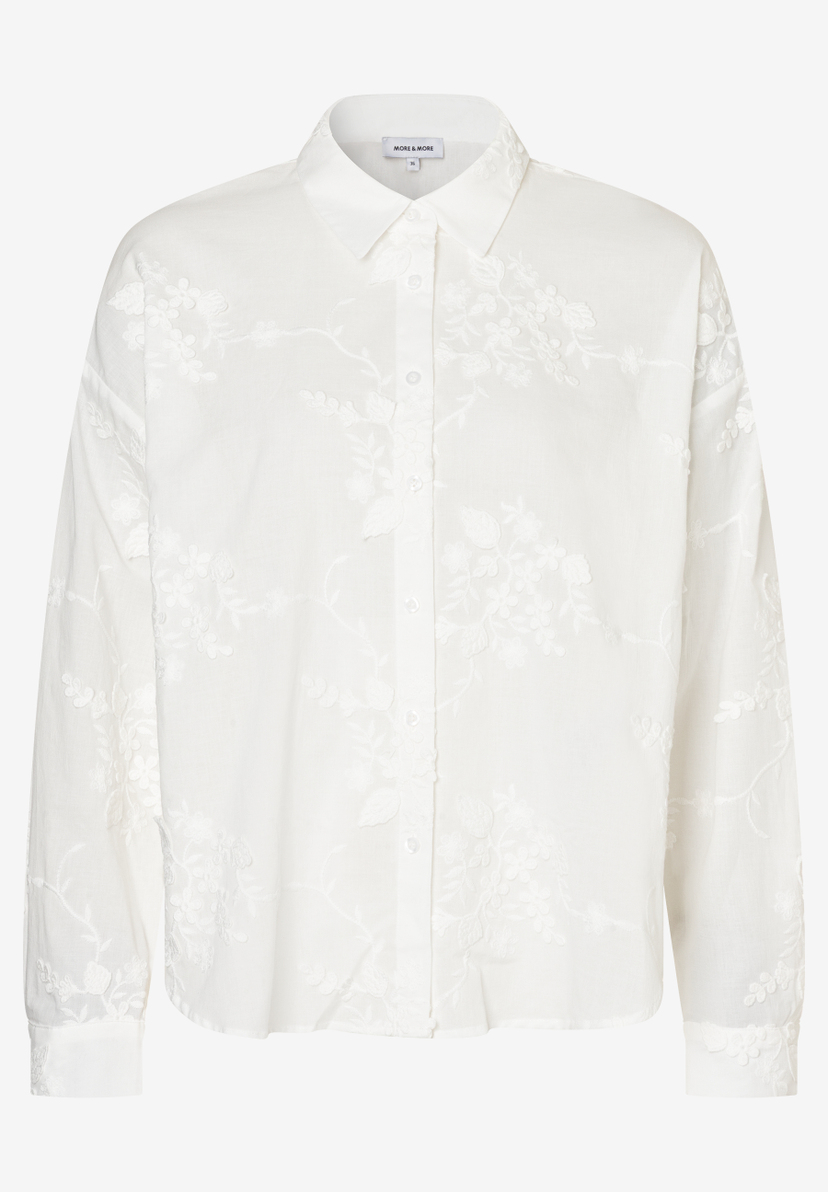 Eine weiße, langärmlige MORE & MORE Bluse mit floralen Stickereien und Knopfleiste.