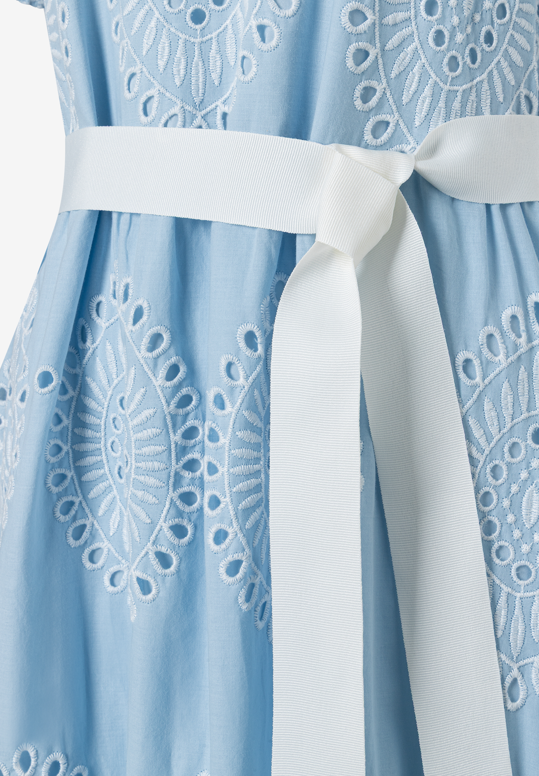 Nahaufnahme des MORE & MORE Oberteils mit weißem Gürtel und Lochstickerei.