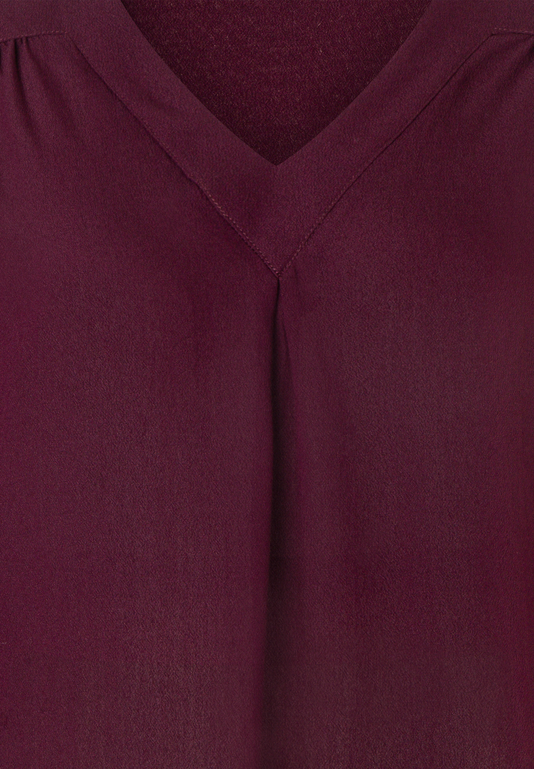 MORE & MORE Bluse: Dunkelrote Bluse mit V-Ausschnitt und angedeutetem Plissee unterhalb des Ausschnitts. MORE & MORE Bluse: Dunkelrote Bluse mit V-Ausschnitt und angedeutetem Plissee unterhalb des Ausschnitts.