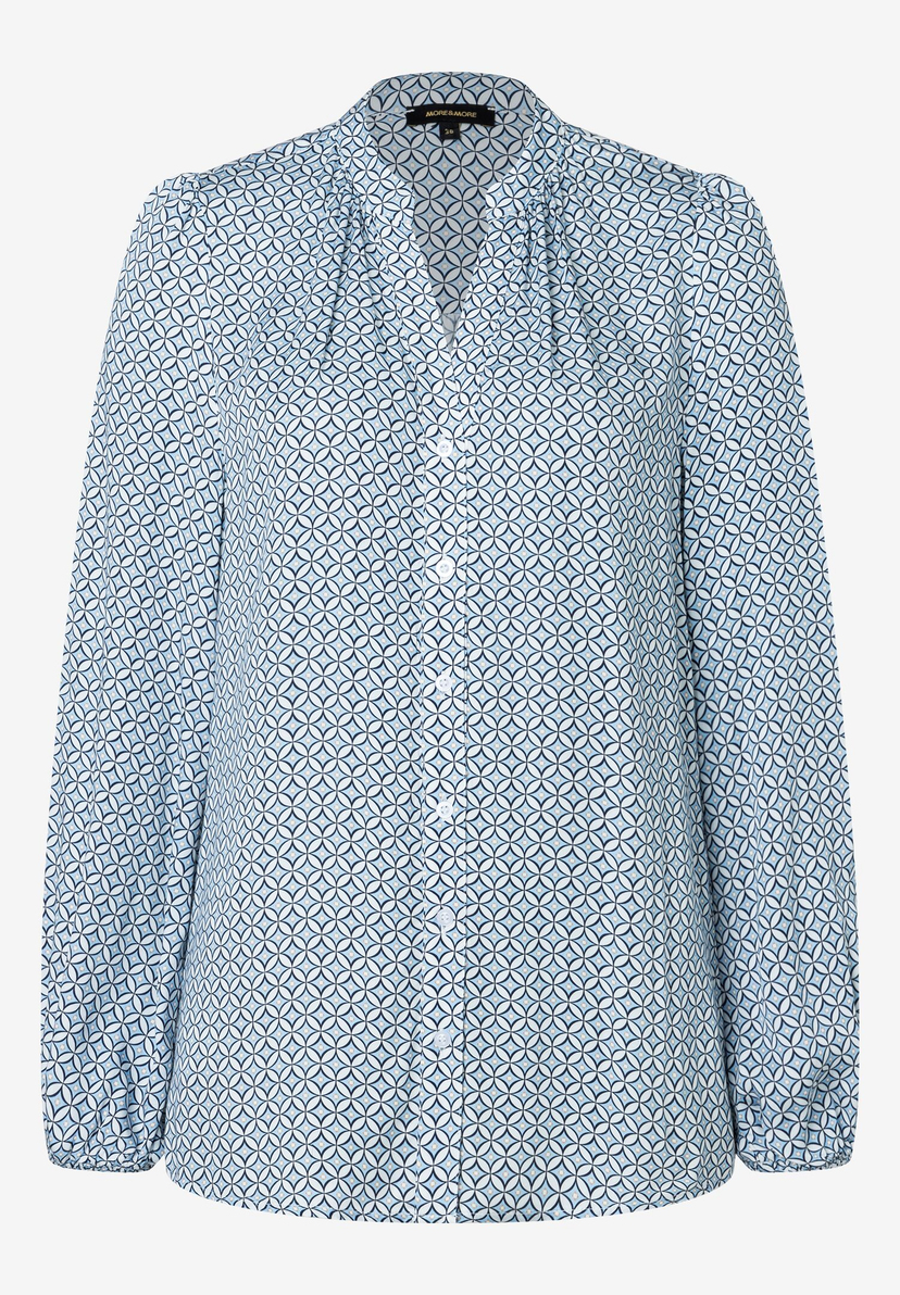 Eine MORE & MORE Bluse mit blauem geometrischem Muster und langen Ärmeln. Eine MORE & MORE Bluse mit blauem geometrischem Muster und langen Ärmeln.