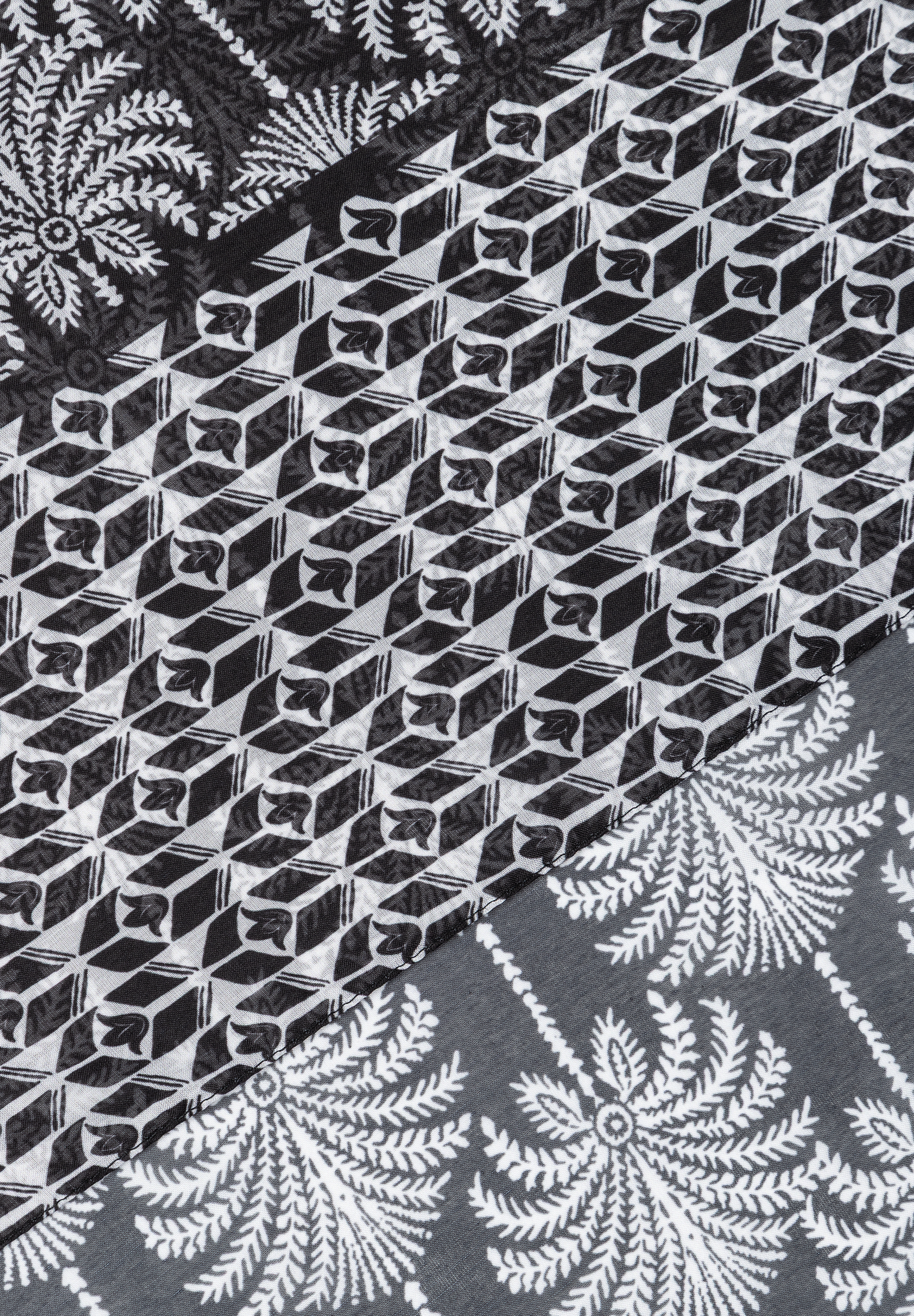 MORE & MORE Accessoire: Detaillierter Stoffausschnitt mit geometrischem Muster und floralen Elementen in Schwarz-Weiß. MORE & MORE Accessoire: Detaillierter Stoffausschnitt mit geometrischem Muster und floralen Elementen in Schwarz-Weiß.