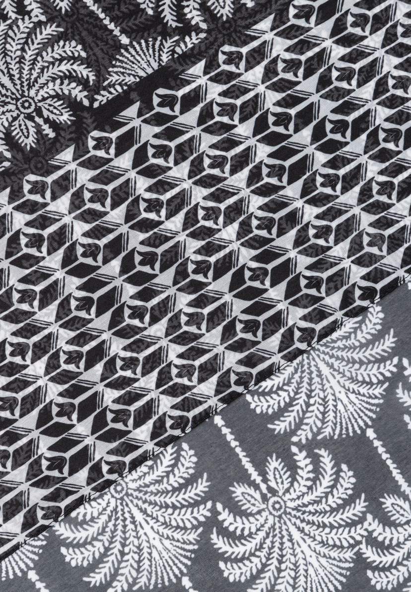 MORE & MORE Accessoire: Detaillierter Stoffausschnitt mit geometrischem Muster und floralen Elementen in Schwarz-Weiß. MORE & MORE Accessoire: Detaillierter Stoffausschnitt mit geometrischem Muster und floralen Elementen in Schwarz-Weiß.