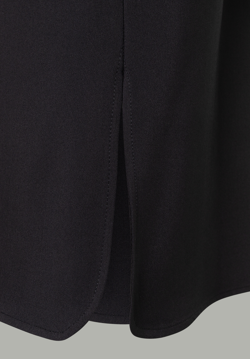 Detailansicht eines schwarzen MORE & MORE Oberteils mit Schlitz am Saum. Stoff und Naht sind gut erkennbar. Detailansicht eines schwarzen MORE & MORE Oberteils mit Schlitz am Saum. Stoff und Naht sind gut erkennbar.