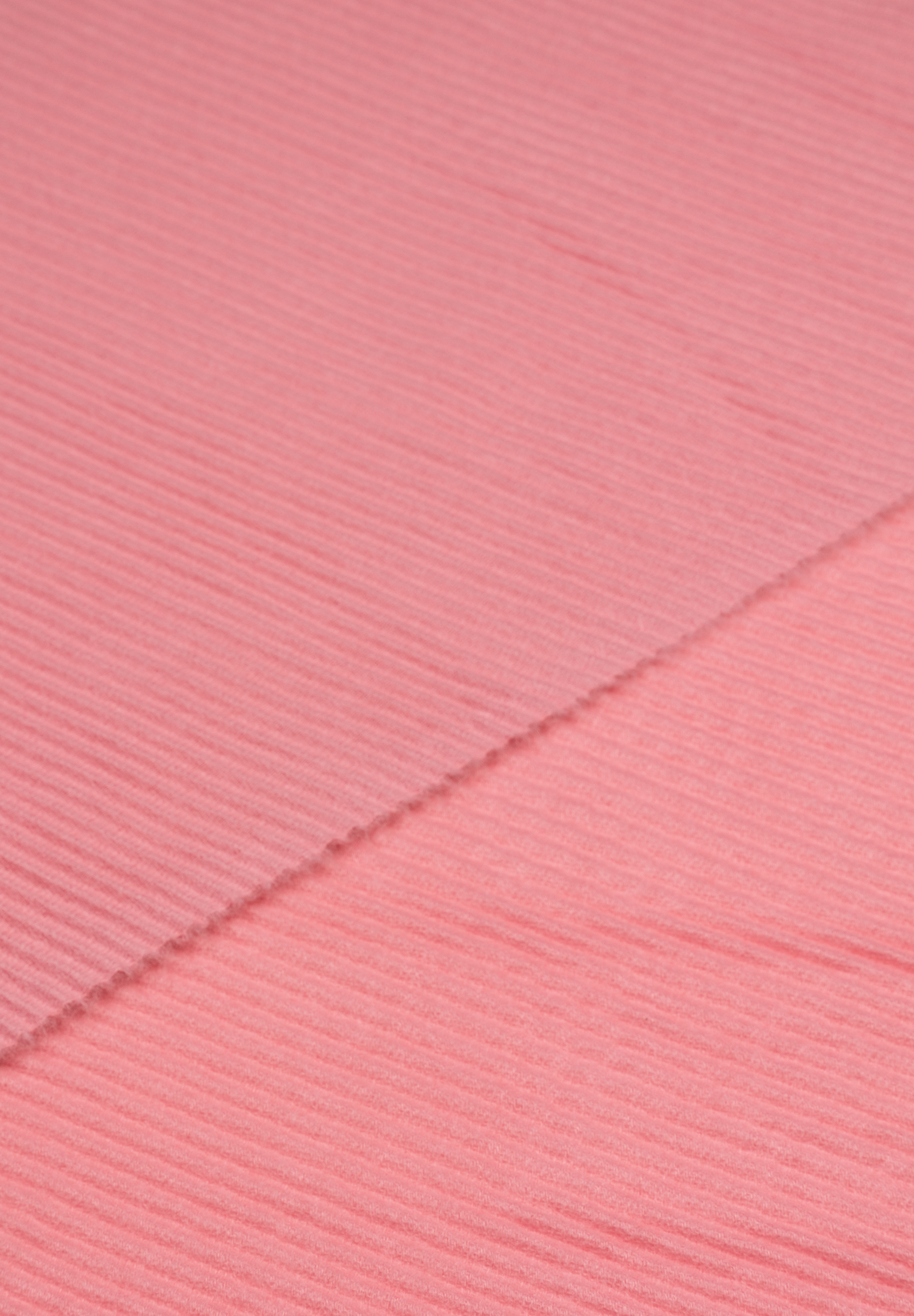 Nahaufnahme eines MORE & MORE Accessoires aus geripptem, rosa Stoff. Nahaufnahme eines MORE & MORE Accessoires aus geripptem, rosa Stoff.