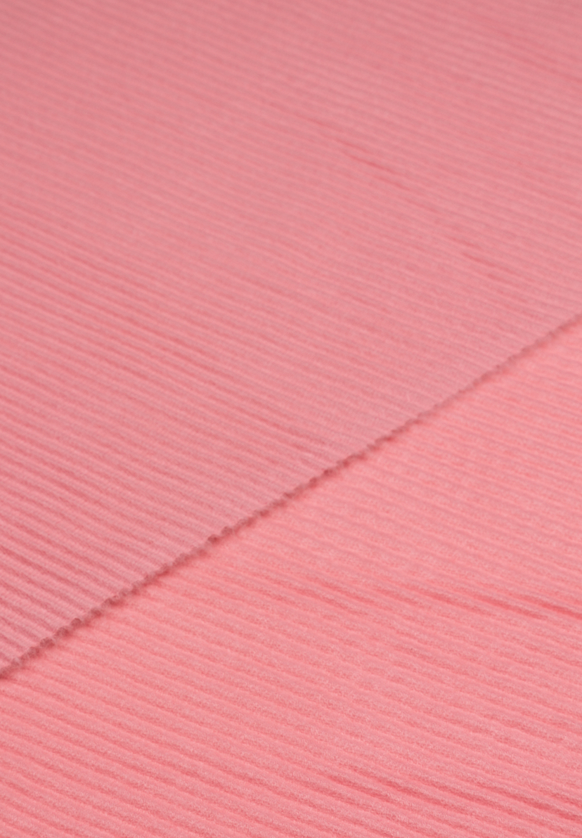 Nahaufnahme eines MORE & MORE Accessoires aus geripptem, rosa Stoff. Nahaufnahme eines MORE & MORE Accessoires aus geripptem, rosa Stoff.