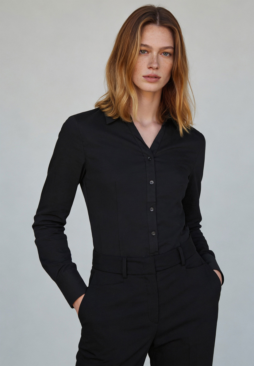 Eine Frau in einer schwarzen MORE & MORE Bluse aus Baumwollmischung mit Stretch. Eine Frau in einer schwarzen MORE & MORE Bluse aus Baumwollmischung mit Stretch.