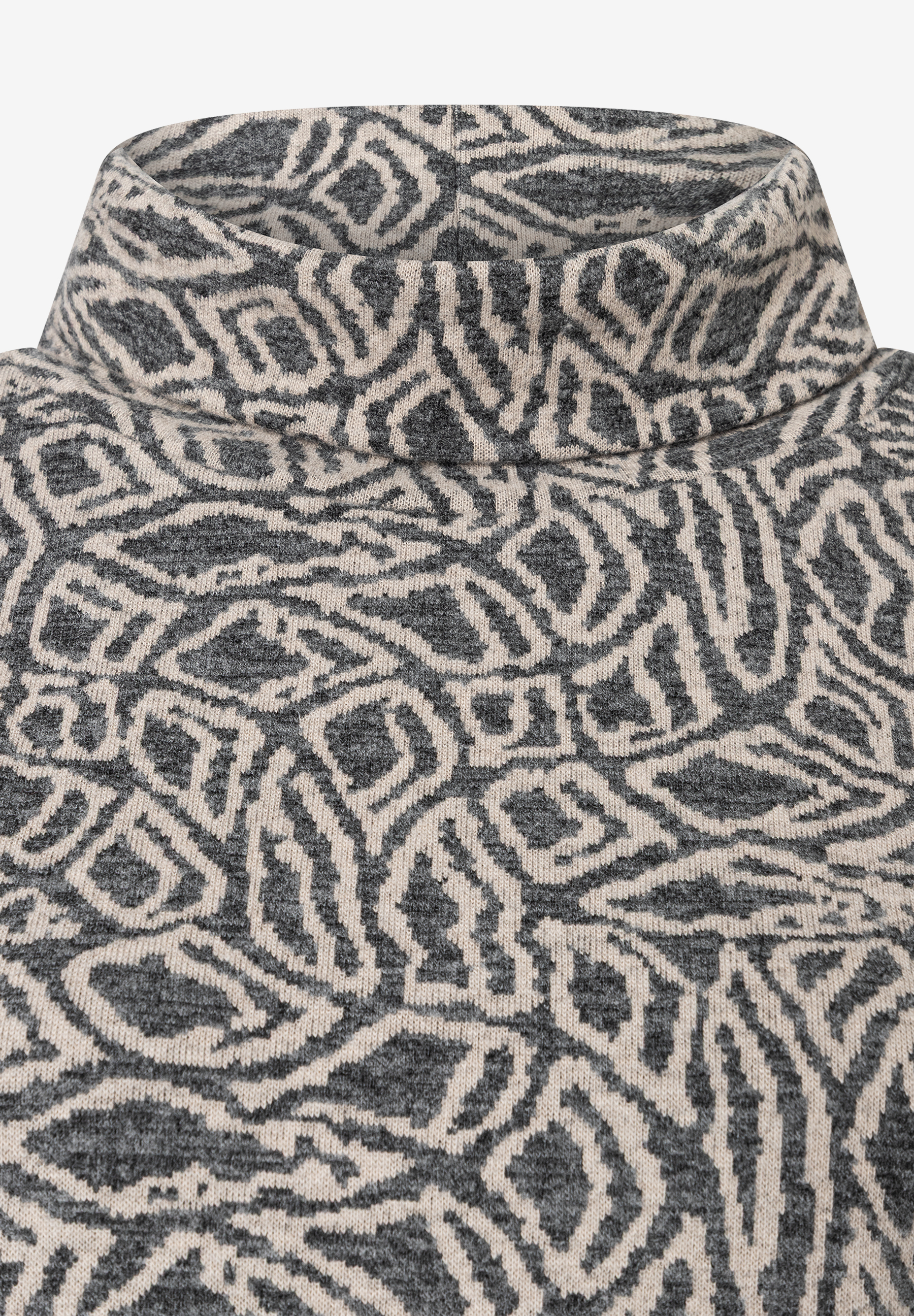 Nahaufnahme eines MORE & MORE Oberteils mit abstraktem Muster und Rollkragen. Nahaufnahme eines MORE & MORE Oberteils mit abstraktem Muster und Rollkragen.
