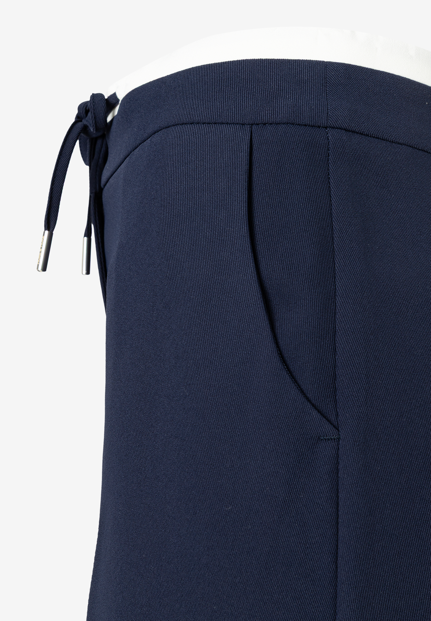 Detailansicht einer marineblauen MORE & MORE Hose mit seitlicher Bindung und einer angedeuteten Tasche. Detailansicht einer marineblauen MORE & MORE Hose mit seitlicher Bindung und einer angedeuteten Tasche.