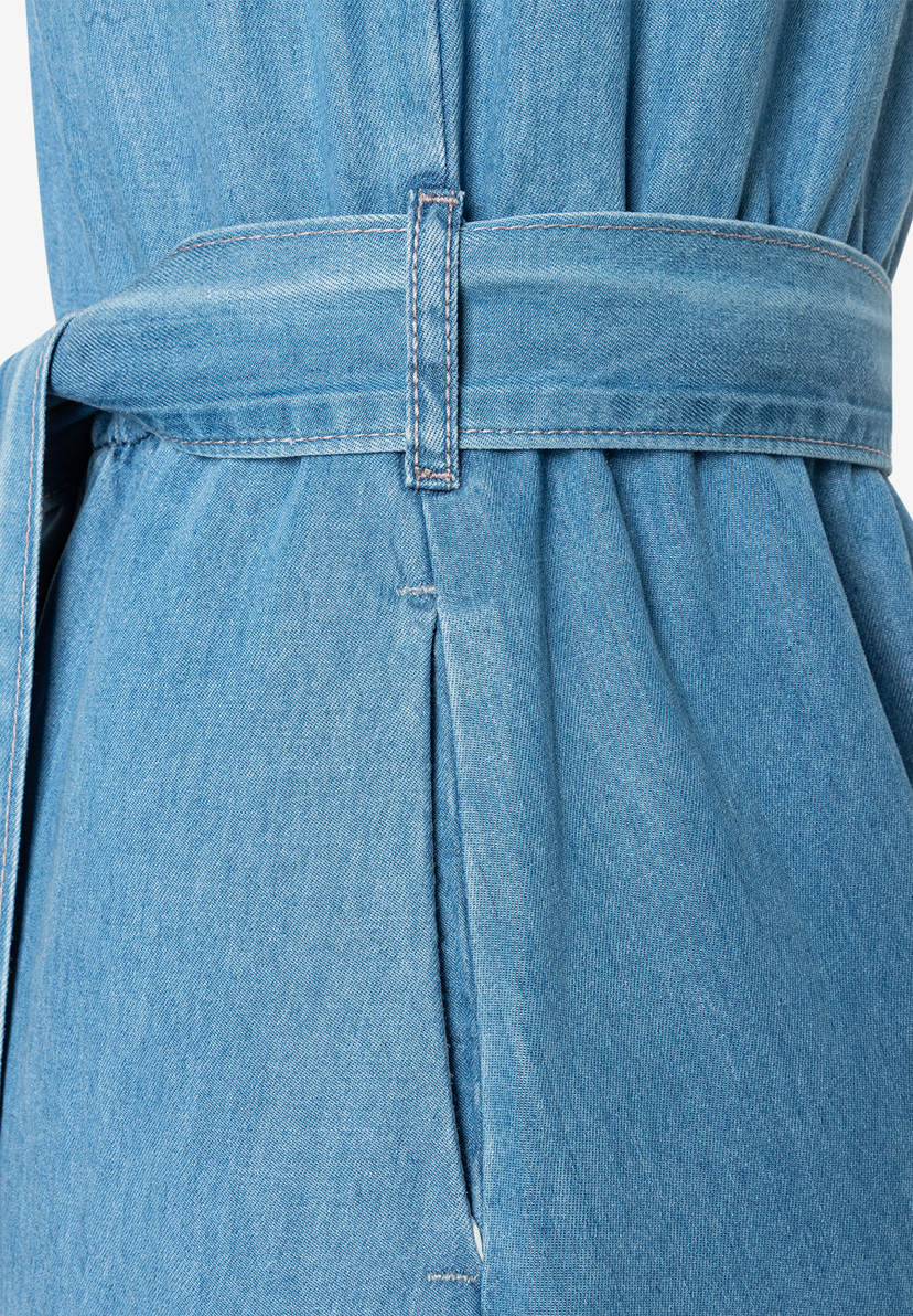Nahaufnahme eines MORE & MORE Denim-Oberteils mit Gürtel und Tasche. Nahaufnahme eines MORE & MORE Denim-Oberteils mit Gürtel und Tasche.
