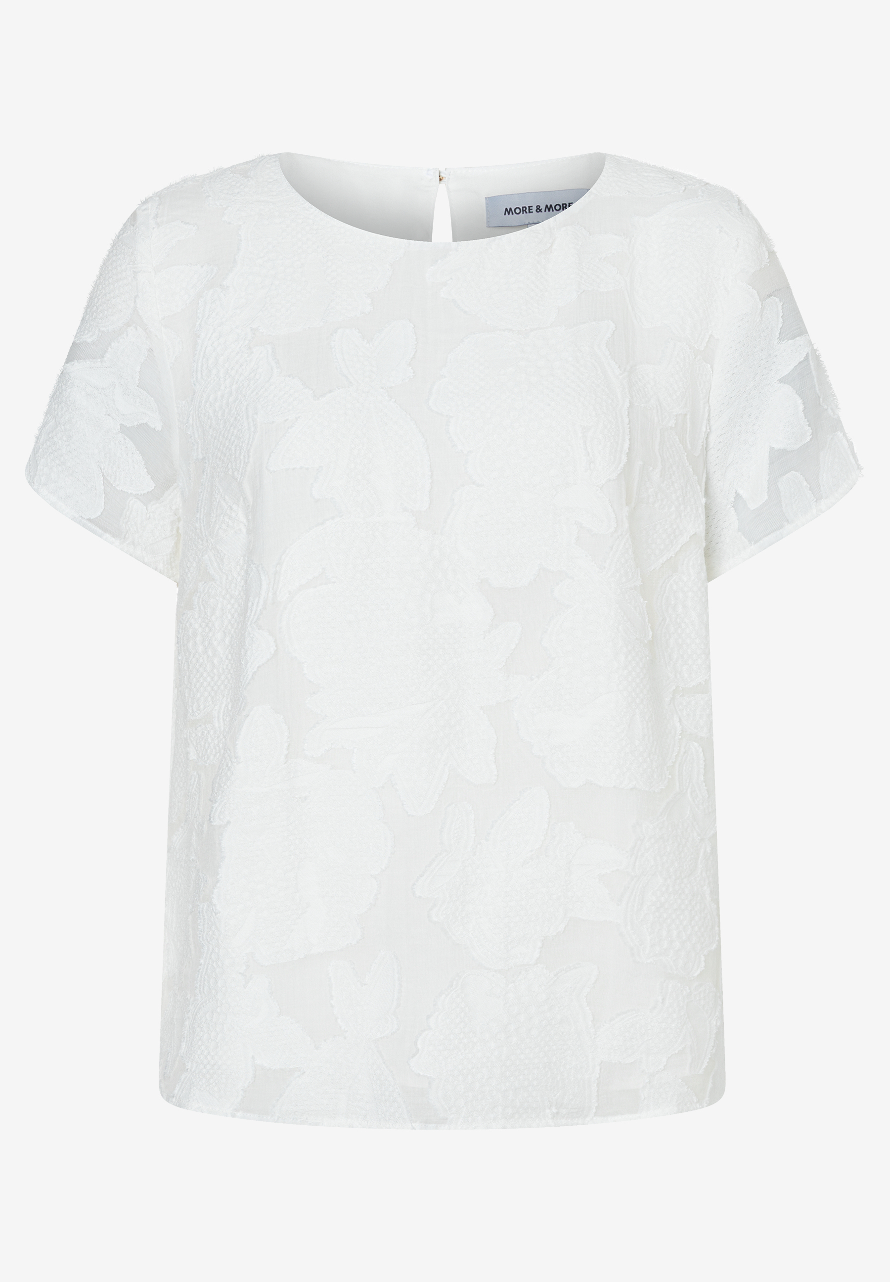 Eine weiße, kurzärmelige MORE & MORE Bluse mit einem floralen Muster auf weißem Hintergrund. Eine weiße, kurzärmelige MORE & MORE Bluse mit einem floralen Muster auf weißem Hintergrund.