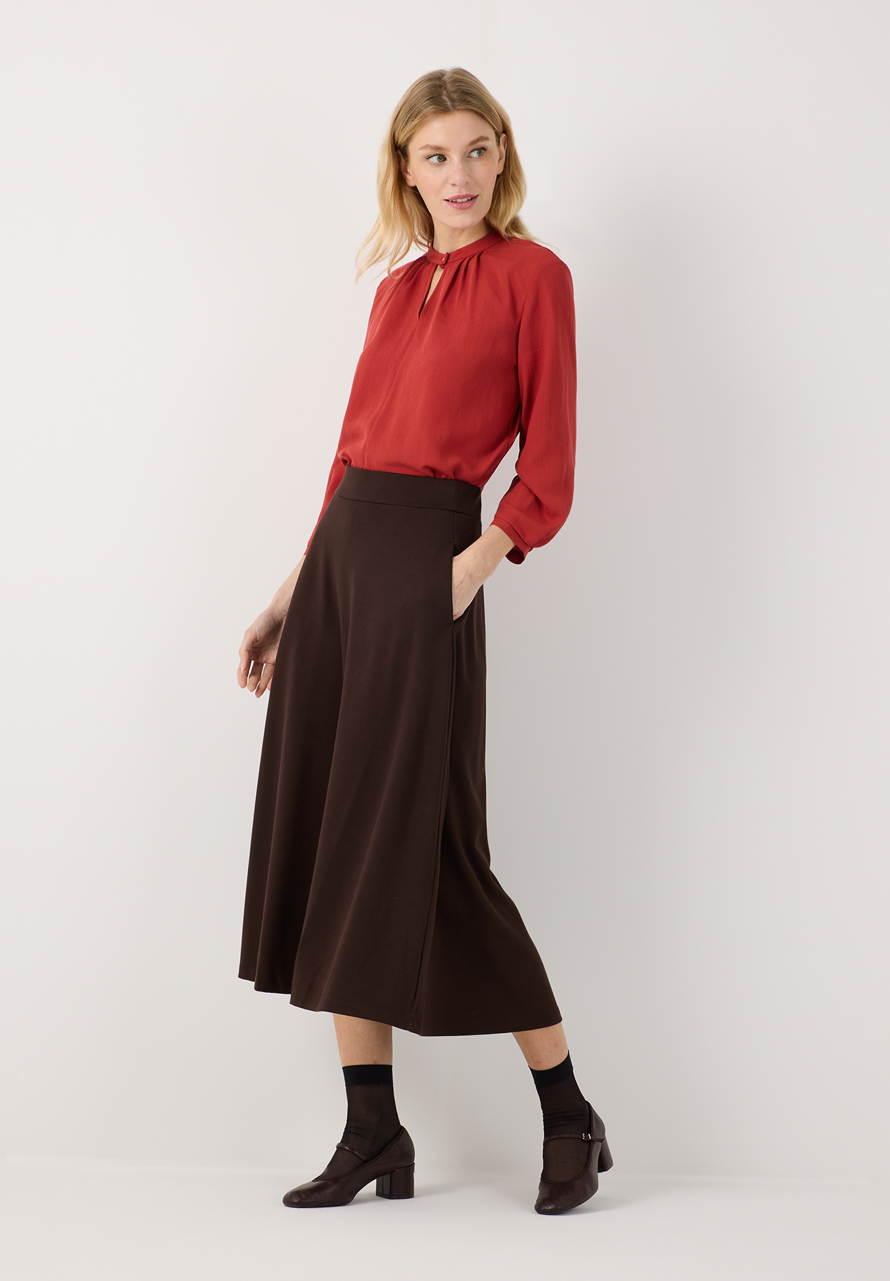 MORE & MORE Bluse aus Webware und Jersey im Materialmix. Rote Bluse mit Rundhalsausschnitt und Schlitz, dazu ein brauner Rock. MORE & MORE Bluse aus Webware und Jersey im Materialmix. Rote Bluse mit Rundhalsausschnitt und Schlitz, dazu ein brauner Rock.