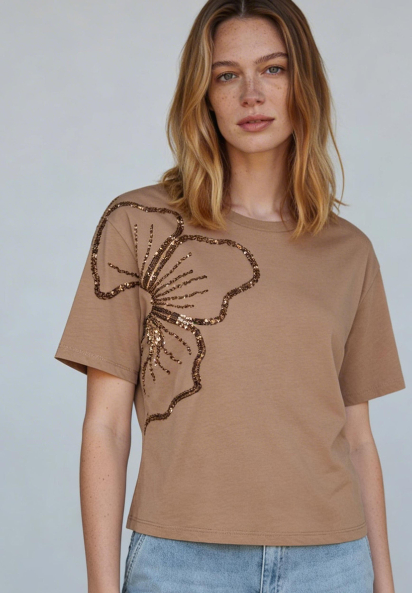 AI generated - Eine Frau trägt ein MORE & MORE T-Shirt mit Jersey-Struktur und einer glitzernden Blumenapplikation. AI generated - Eine Frau trägt ein MORE & MORE T-Shirt mit Jersey-Struktur und einer glitzernden Blumenapplikation.