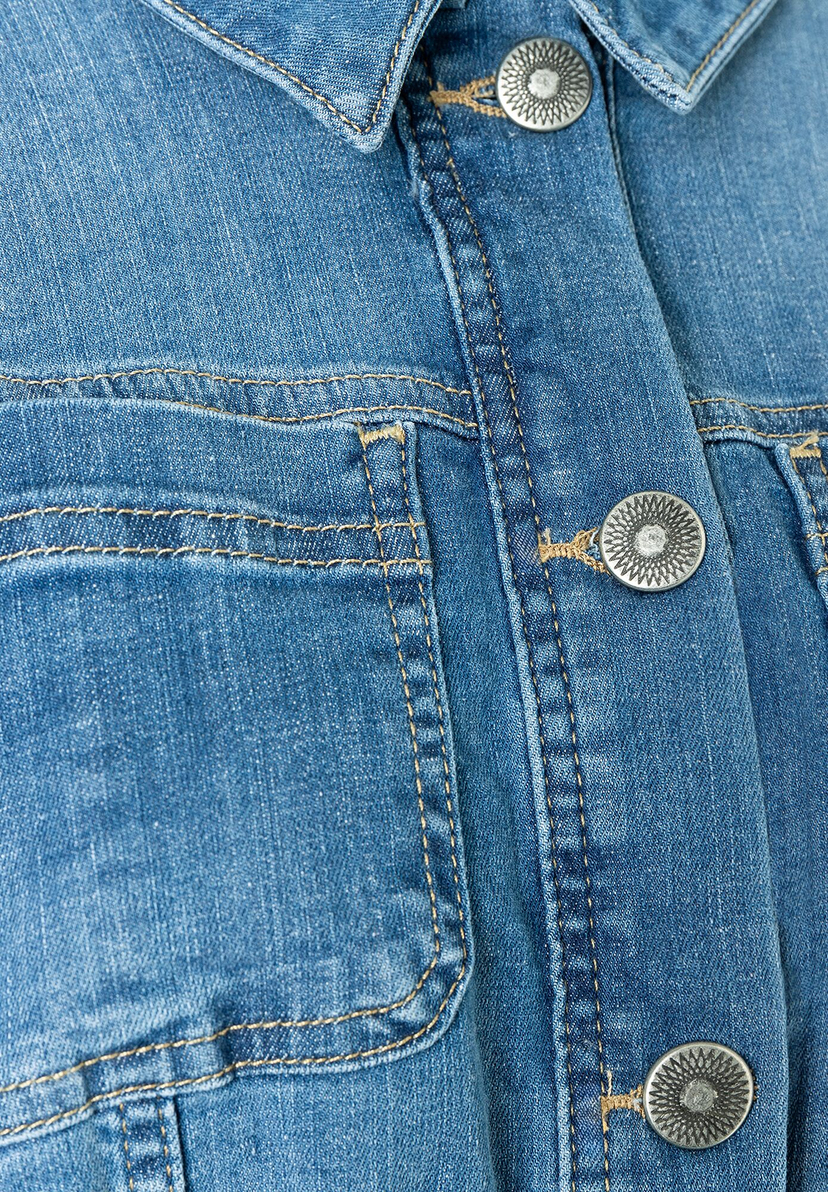 Nahaufnahme einer Jeansjacke von MORE & MORE mit Ziernähten und Knöpfen. Nahaufnahme einer Jeansjacke von MORE & MORE mit Ziernähten und Knöpfen.