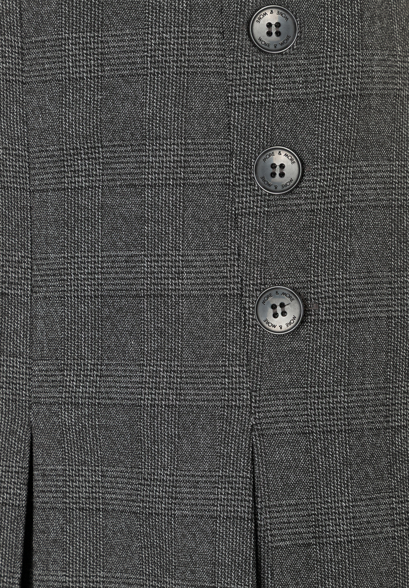 Nahaufnahme eines MORE & MORE Rocks mit Webware-Struktur und Knöpfen, die den Markennamen zeigen. Nahaufnahme eines MORE & MORE Rocks mit Webware-Struktur und Knöpfen, die den Markennamen zeigen.