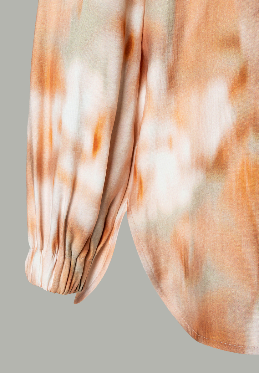 Nahaufnahme einer MORE & MORE Bluse mit abstraktem Muster und gerafftem Ärmel. Nahaufnahme einer MORE & MORE Bluse mit abstraktem Muster und gerafftem Ärmel.