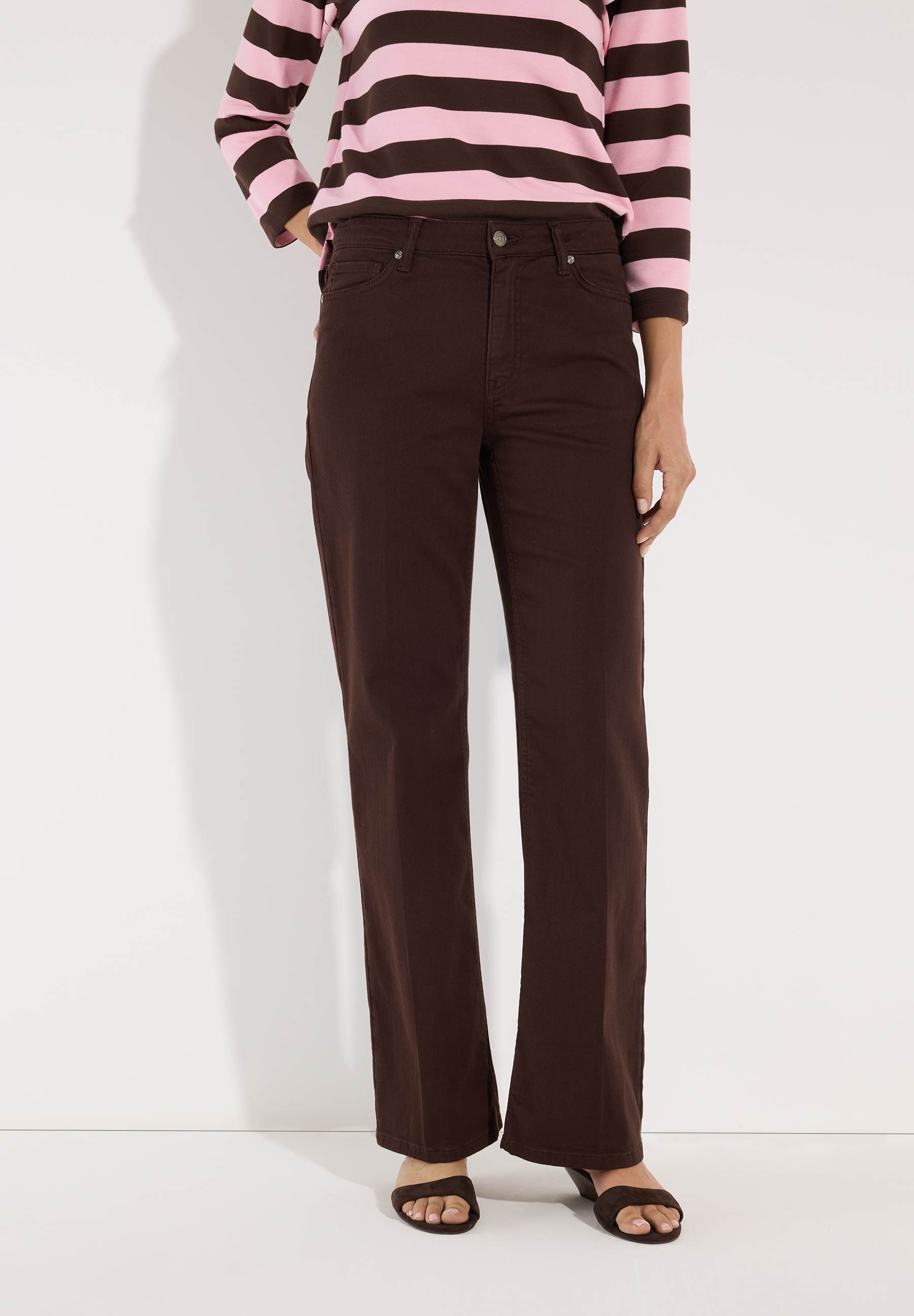 MORE & MORE Jeans: dunkelbraune Bootcut-Hose aus Denim. Kombiniert mit pink-braun gestreiftem Oberteil & offenen Schuhen.