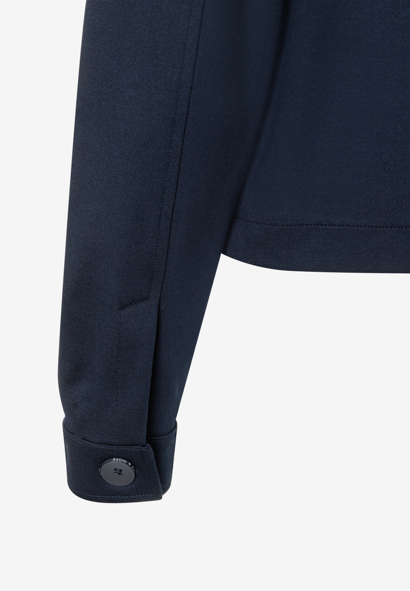Detailansicht eines marineblauen MORE & MORE Blazers mit Jersey-Material, Manschette und Knopf. Detailansicht eines marineblauen MORE & MORE Blazers mit Jersey-Material, Manschette und Knopf.