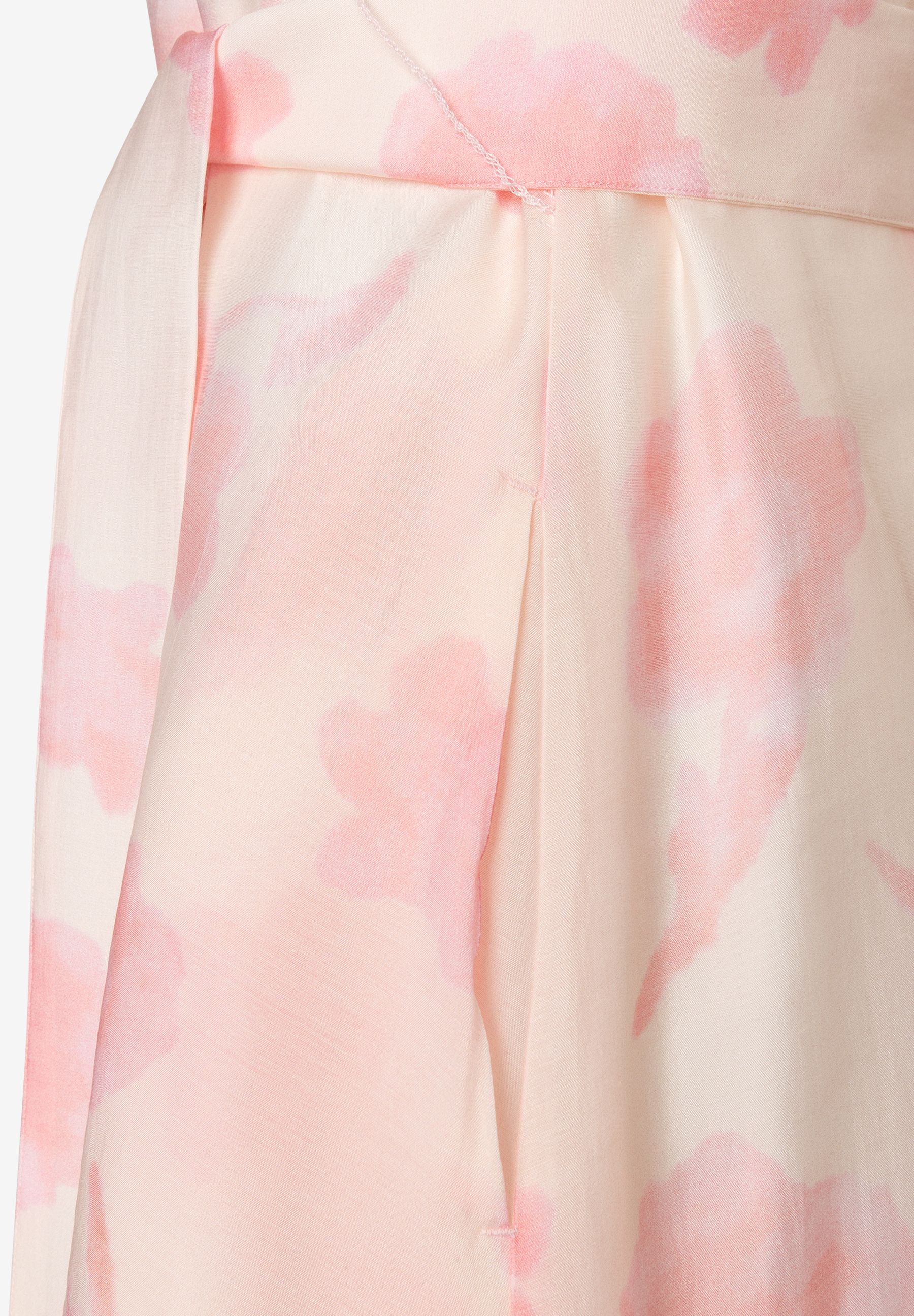 Detailaufnahme eines Oberteils von MORE & MORE mit Chiffon und rosafarbenen Blumenmuster. Detailaufnahme eines Oberteils von MORE & MORE mit Chiffon und rosafarbenen Blumenmuster.