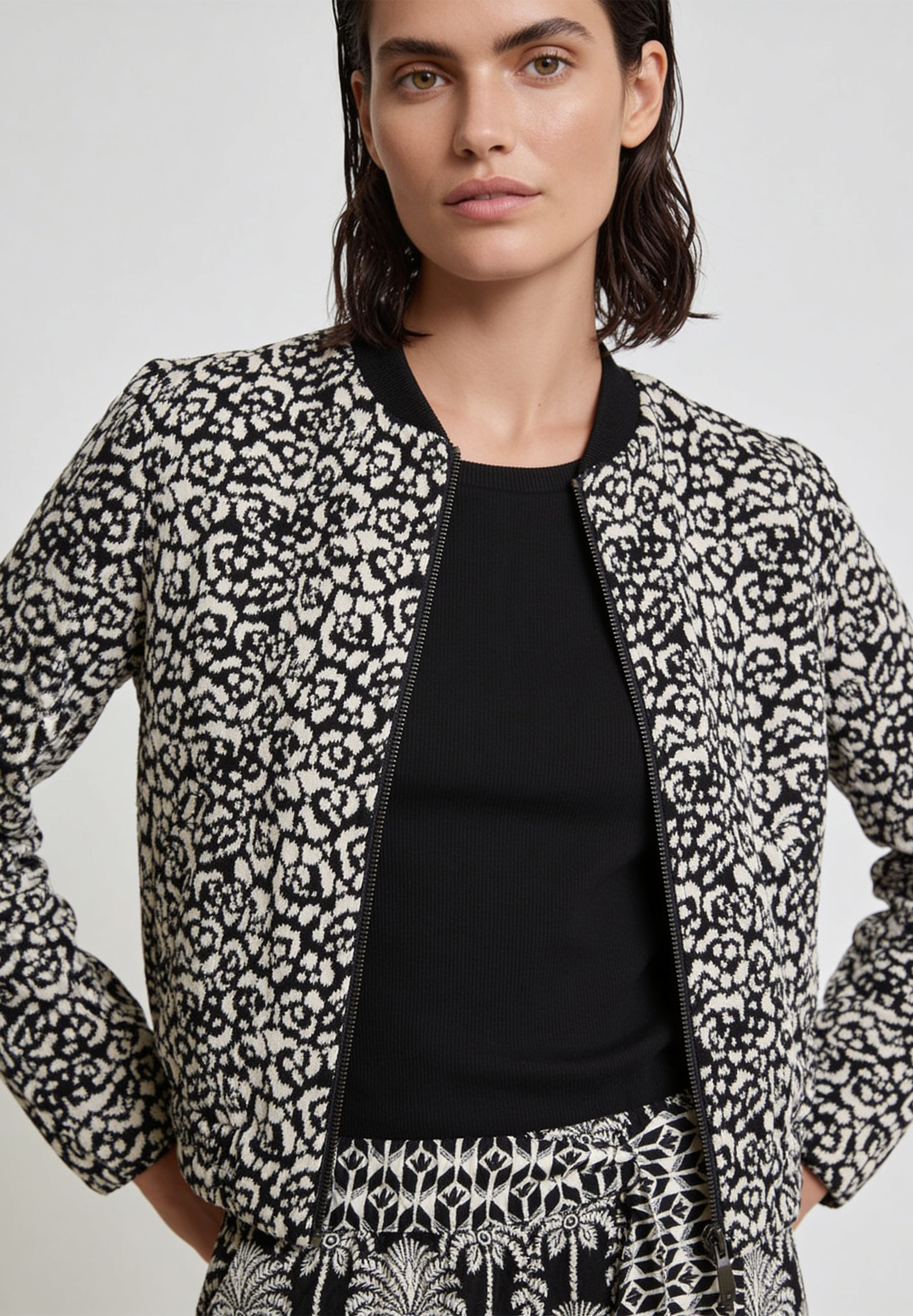 MORE & MORE Blazer in Schwarz-Ecru mit Tiermuster, Reißverschluss, Bundkragen und Gummizug an Ärmelenden.