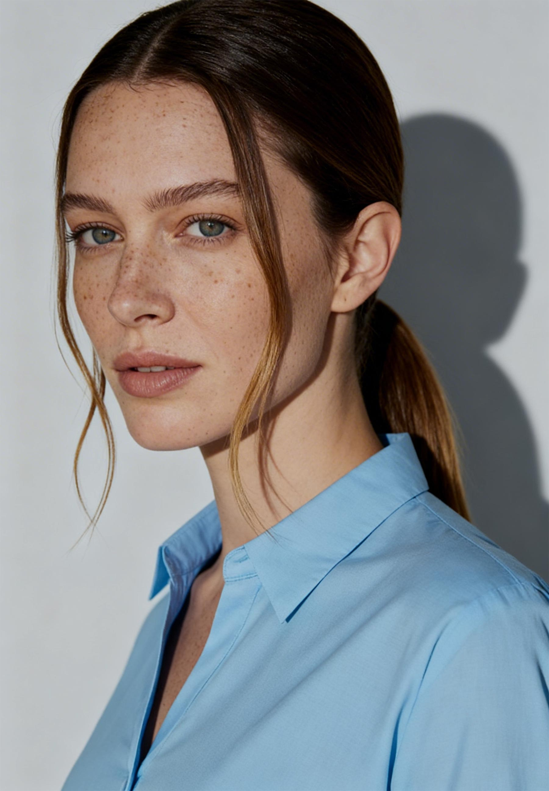 Porträt einer Frau in hellblauer MORE & MORE Popeline-Bluse.