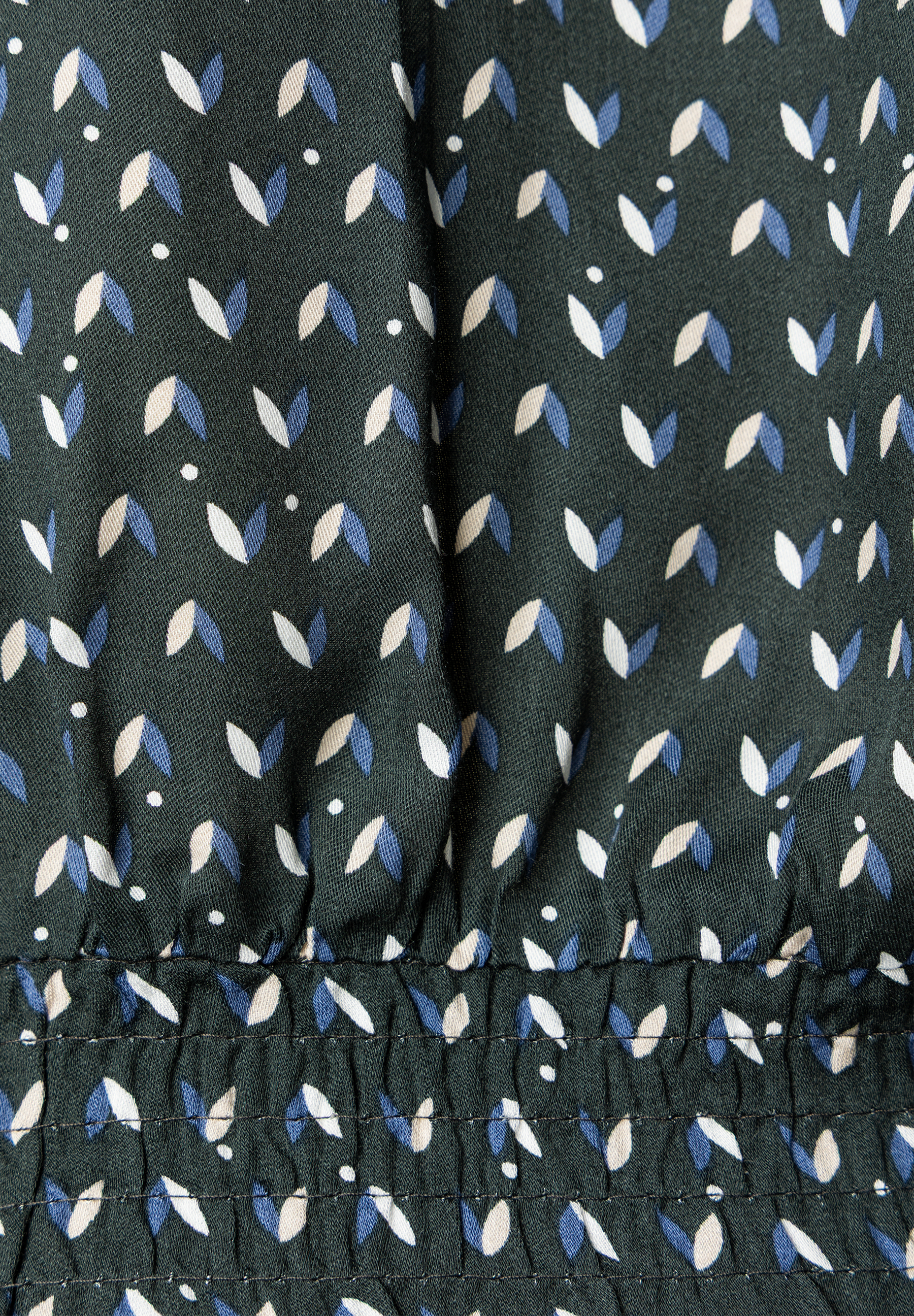 MORE & MORE Bluse: Dunkelgrüner Stoff mit Muster aus blauen, beigen und weißen Blättern, unten gesmokt. MORE & MORE Bluse: Dunkelgrüner Stoff mit Muster aus blauen, beigen und weißen Blättern, unten gesmokt.