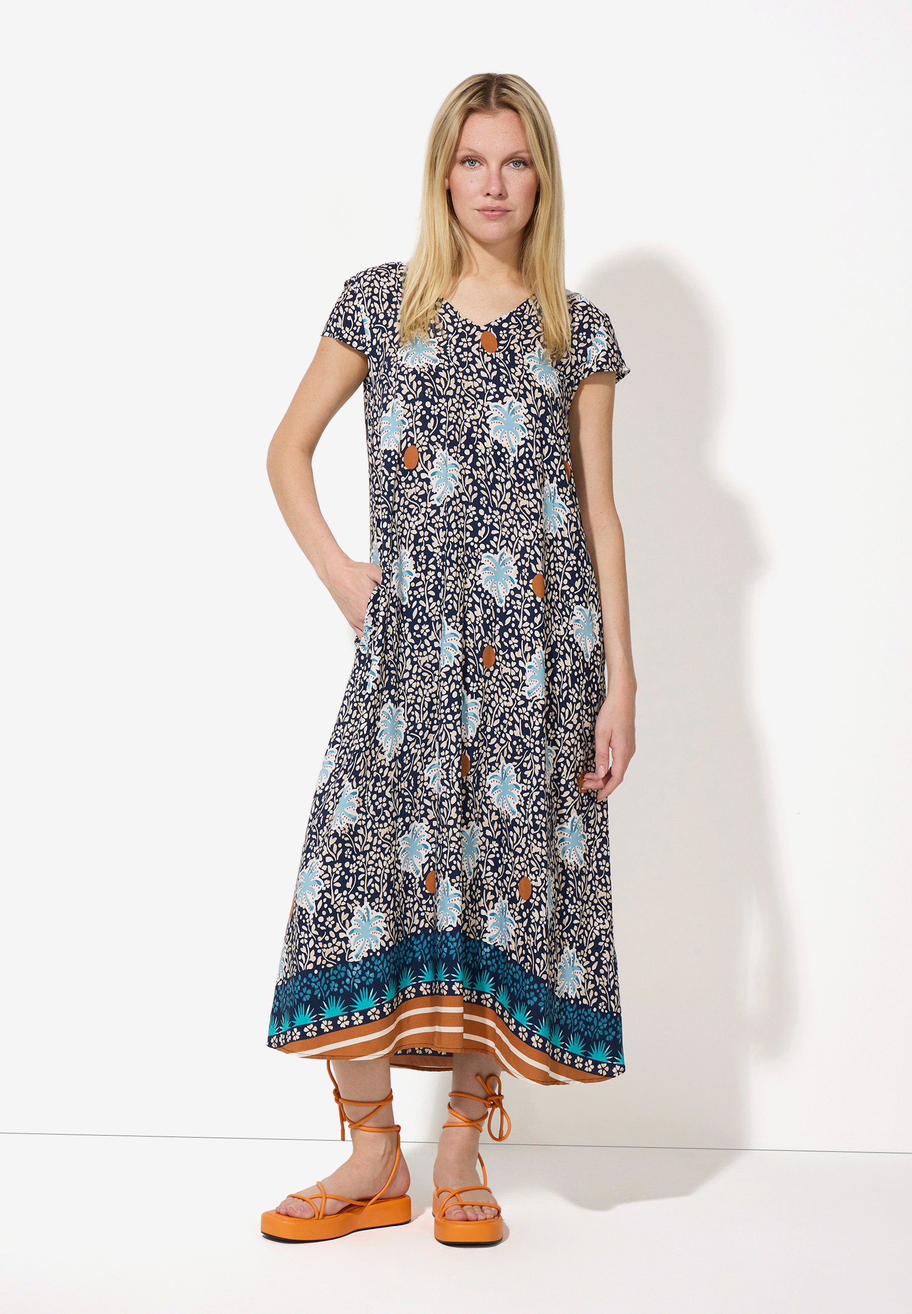 Eine Frau im MORE & MORE-Oberteil mit fließendem, leichtem Viskose-Material und Blumenmuster.