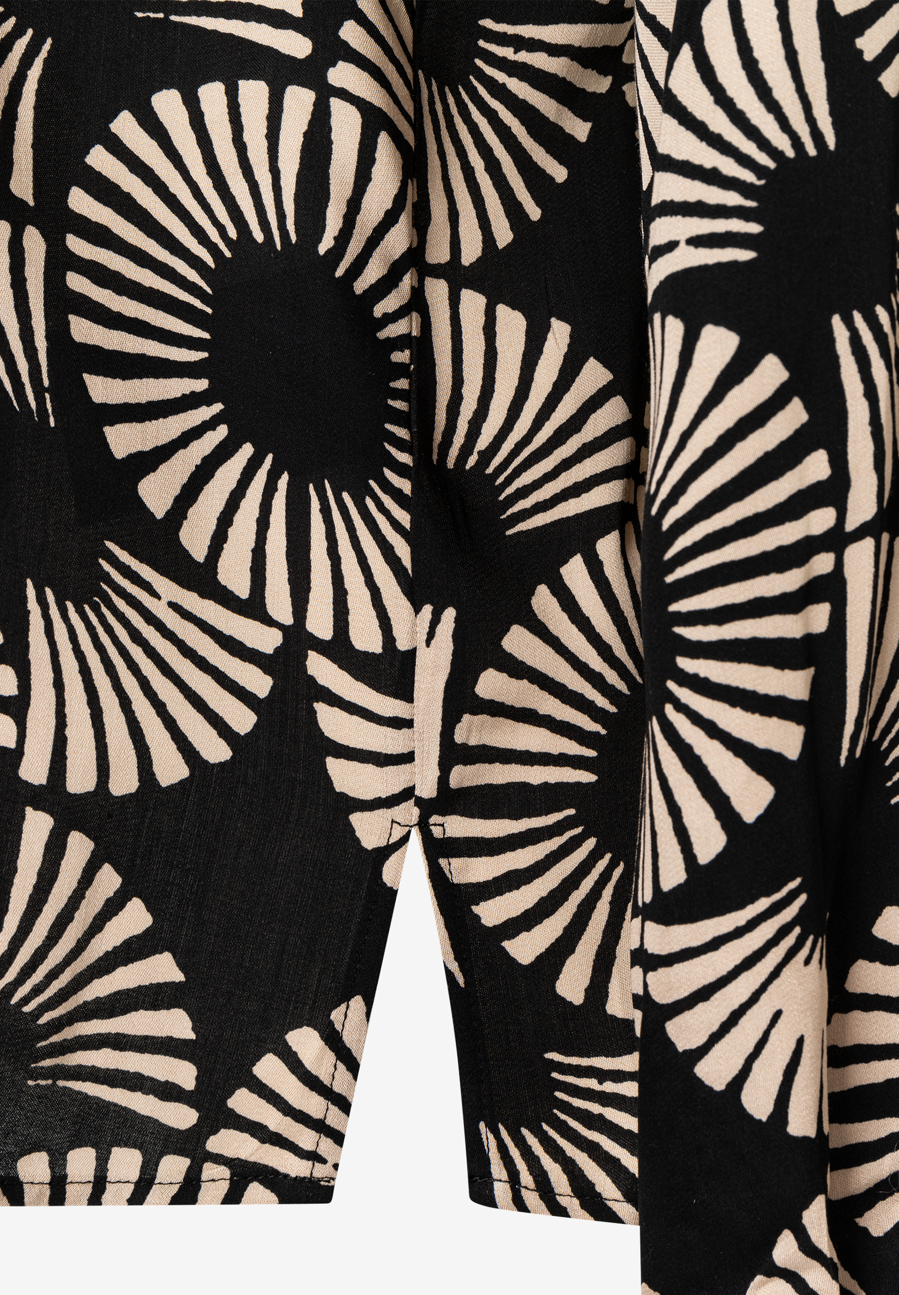 Nahaufnahme einer fließenden MORE & MORE Bluse mit abstraktem Muster. Nahaufnahme einer fließenden MORE & MORE Bluse mit abstraktem Muster.