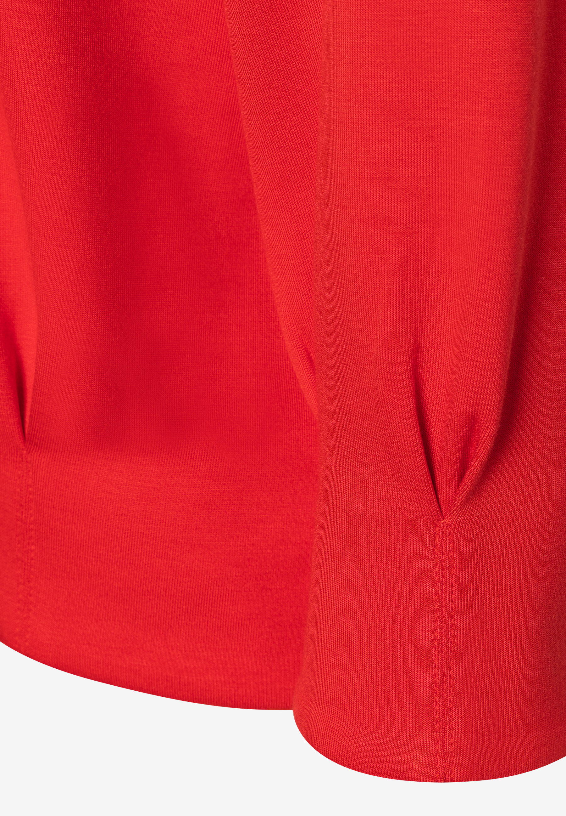 Nahaufnahme von Ärmel und Saum eines roten MORE & MORE Sweatshirts. Nahaufnahme von Ärmel und Saum eines roten MORE & MORE Sweatshirts.