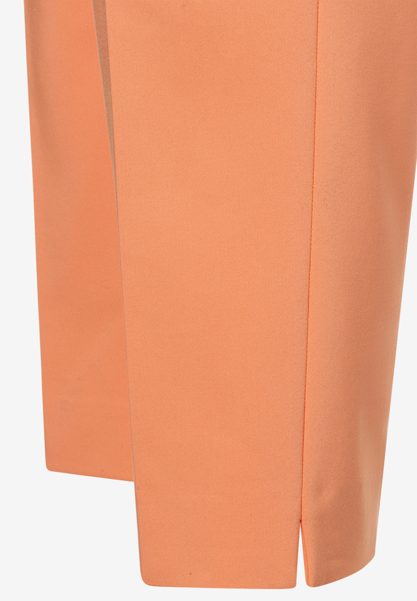 Detailaufnahme einer apricotfarbenen MORE & MORE Baumwollmischhose, die den Stoff und einen kleinen Schlitz zeigt.