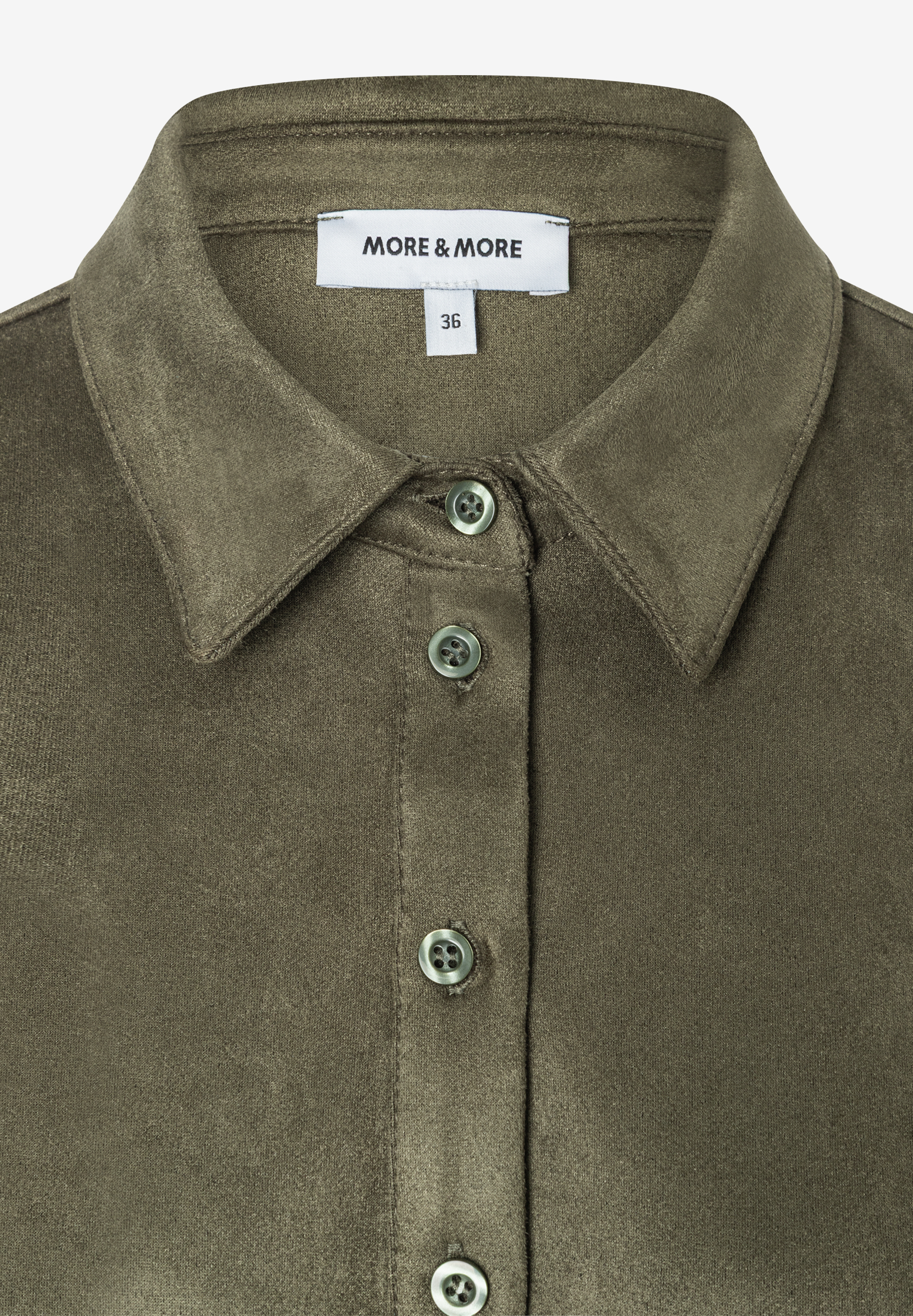 Nahaufnahme eines olivgrünen MORE & MORE Oberteils mit Knopfleiste, Kragen und Größenetikett 36. Nahaufnahme eines olivgrünen MORE & MORE Oberteils mit Knopfleiste, Kragen und Größenetikett 36.