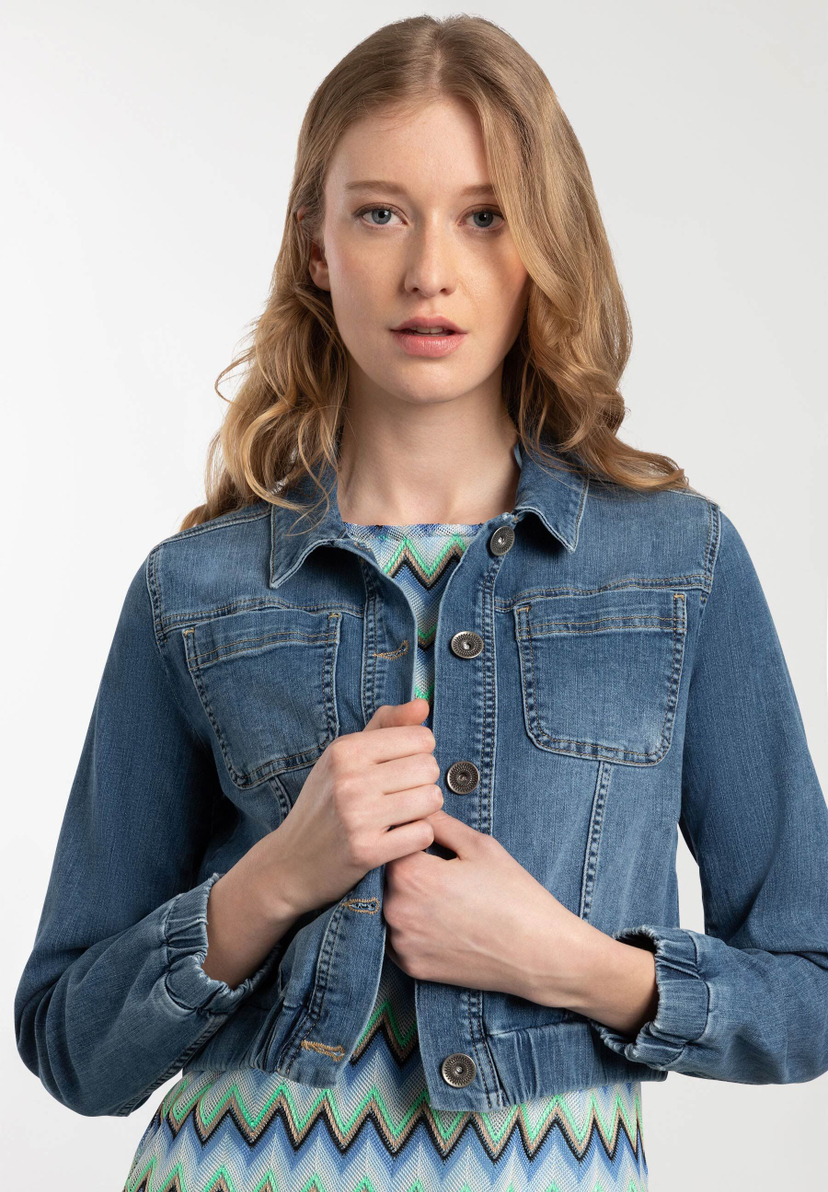 Eine Frau präsentiert eine blaue Jeansjacke von MORE & MORE. Das Oberteil ist aus Denim und bietet angenehmen Tragekomfort. Eine Frau präsentiert eine blaue Jeansjacke von MORE & MORE. Das Oberteil ist aus Denim und bietet angenehmen Tragekomfort.