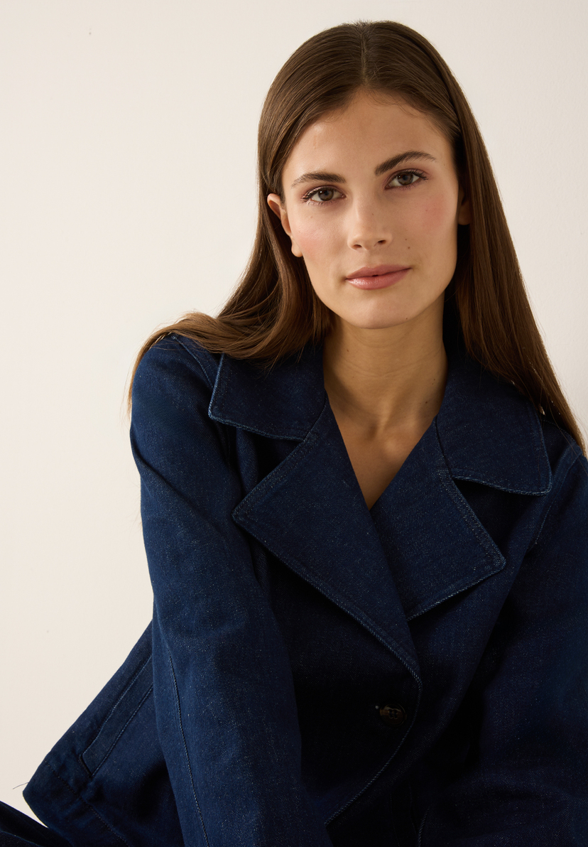 Eine Frau trägt ein MORE & MORE Oberteil aus Denim. Die strapazierfähige Jacke hat einen Kragen und Knöpfe. Eine Frau trägt ein MORE & MORE Oberteil aus Denim. Die strapazierfähige Jacke hat einen Kragen und Knöpfe.