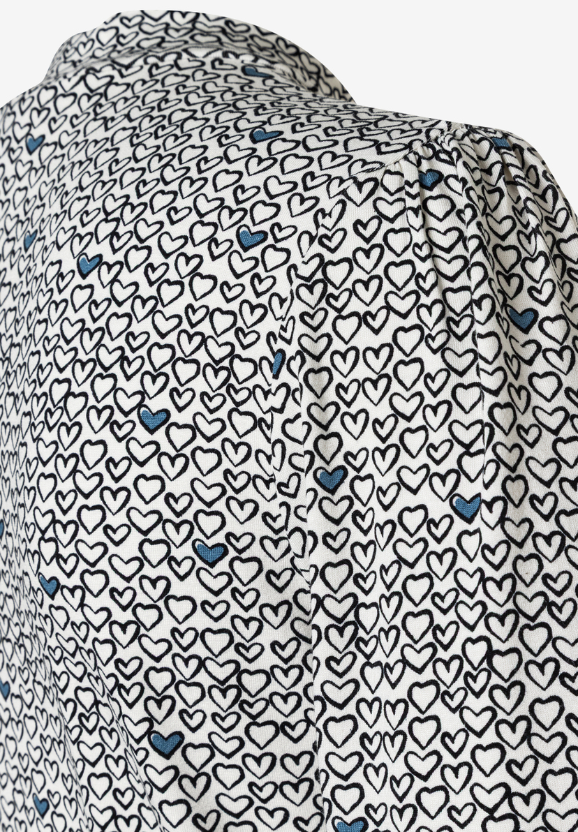 Nahaufnahme eines MORE & MORE Oberteils mit Herzmuster und Jersey-Material. Nahaufnahme eines MORE & MORE Oberteils mit Herzmuster und Jersey-Material.