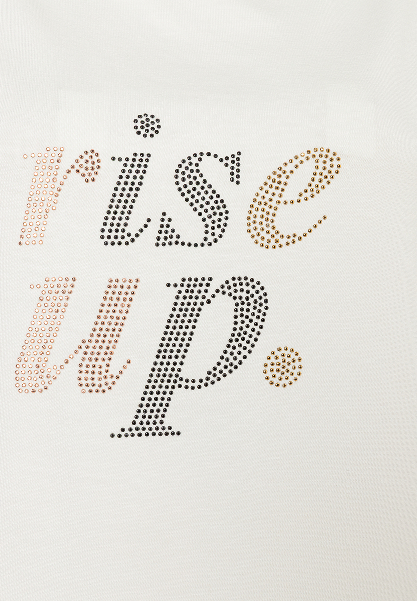 Nahaufnahme eines MORE & MORE Oberteils mit "rise up."-Schriftzug aus farbigen Ziersteinen. Nahaufnahme eines MORE & MORE Oberteils mit "rise up."-Schriftzug aus farbigen Ziersteinen.